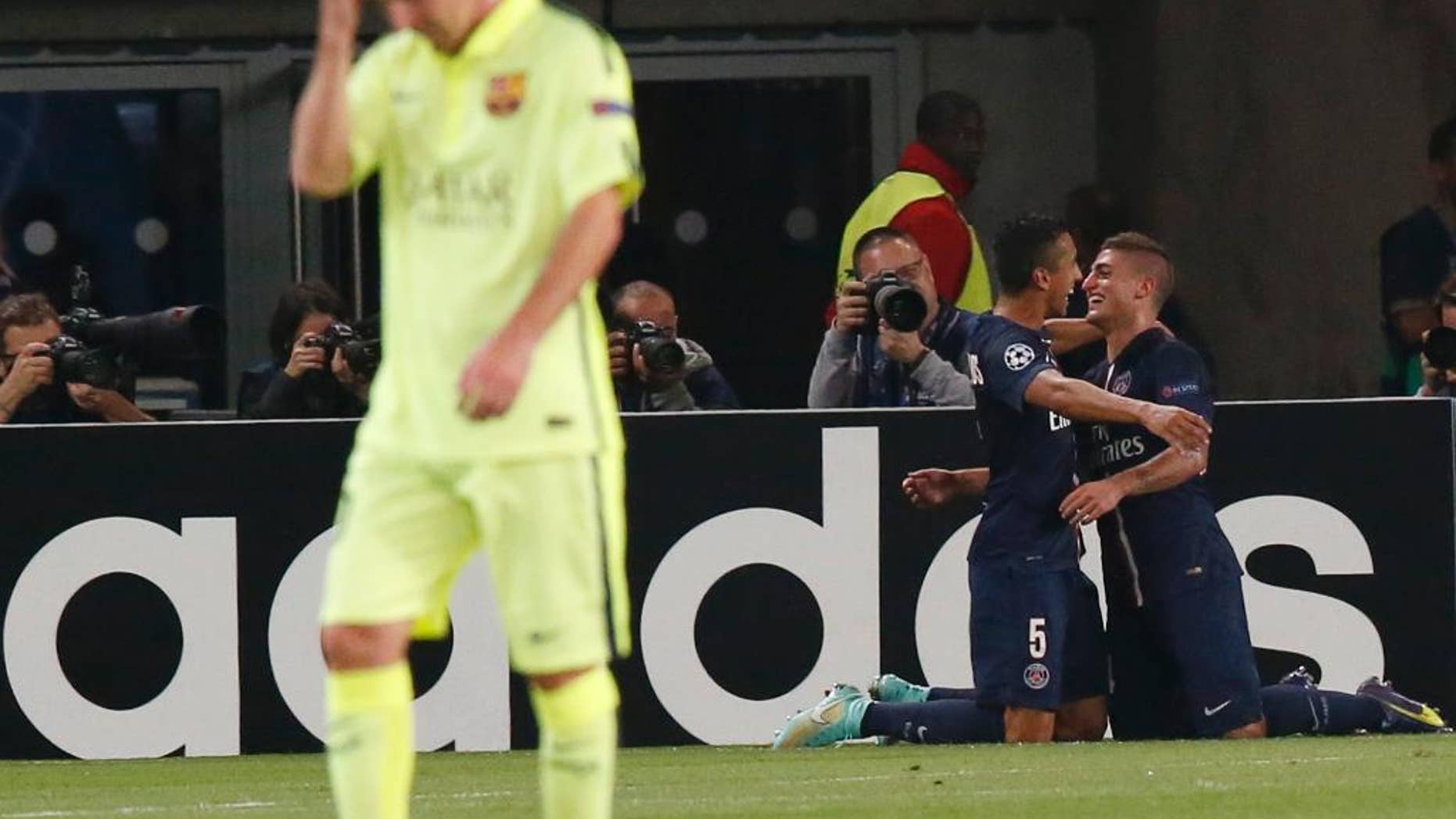 PSG's Marco Verratti, right, is congratulated by PSG's Marquinhos after scoring his side's 2nd goal, while Barcelona's Lionel Messi, left, passes by during the Champions League Group F soccer match between Paris Saint German and Barcelona at Parc des Princes stadium in Paris, France, Tuesday, Sept. 30, 2014. (AP Photo/Michel Euler)