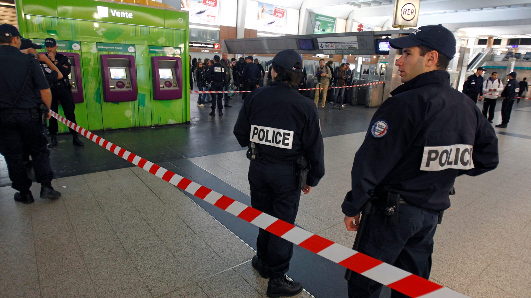 May 25, 2013: Police officers stand near the cordoned off spot where a French soldier was stabbed in the throat in the busy commercial district of La Defense, outside Paris, and France's president said authorities are investigating any possible links with the recent slaying of a British soldier.