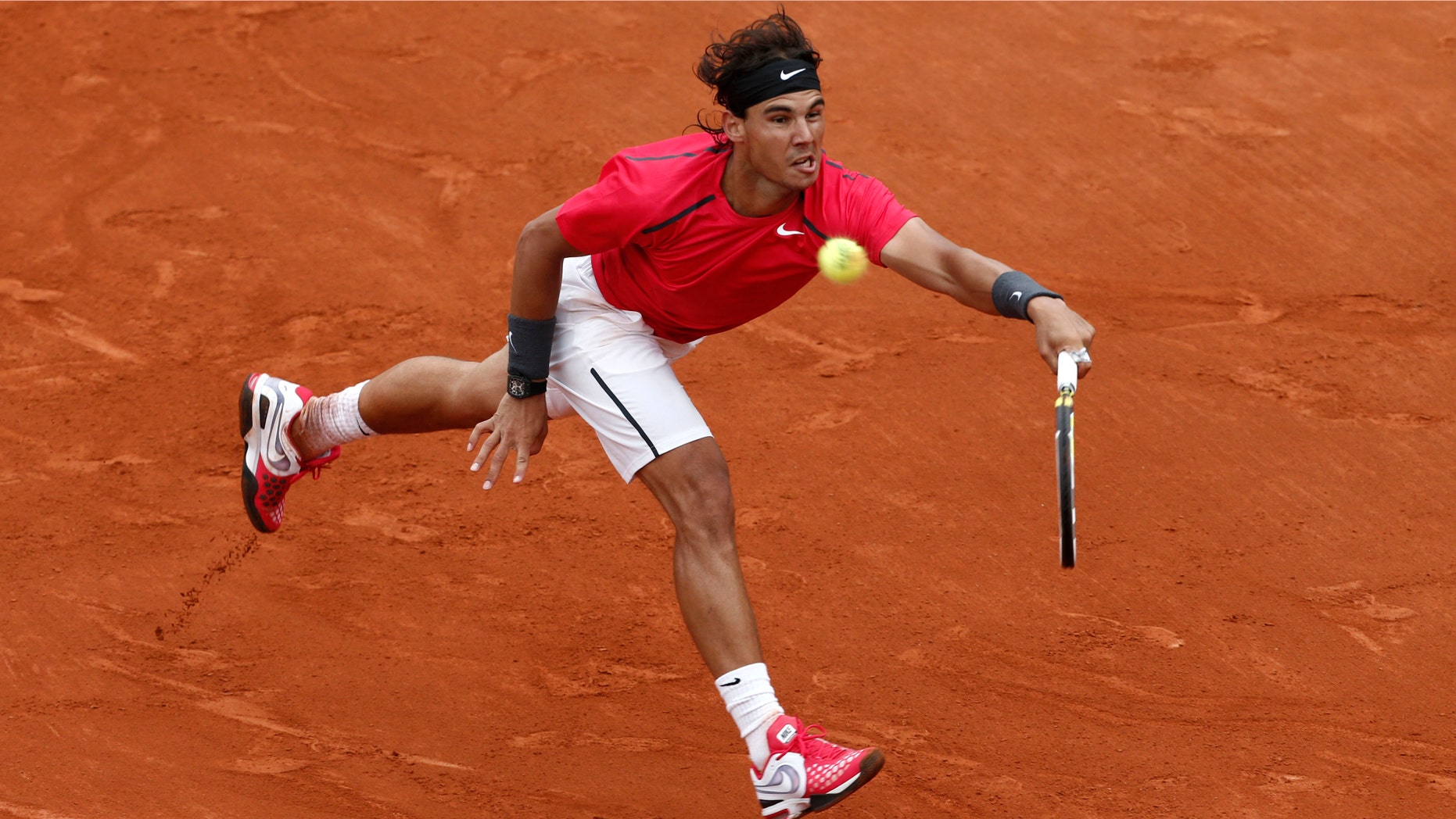 Rafael Nadal returns the ball to compatriot Nicolas Almagro during their quarterfinal match in the French Open tennis tournament at the Roland Garros stadium in Paris, Wednesday, June 6, 2012.