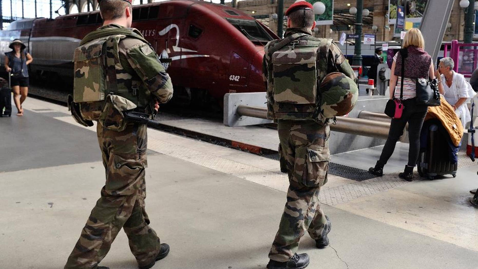 FILE - In this Aug. 22, 2015 file photo, French soldiers patrol at Gare du Nord train station in Paris, France. France is tightening security on its vast public transit network after the attack on a high-speed Thalys train thwarted by a group of American friends. (AP Photo/Binta, File)