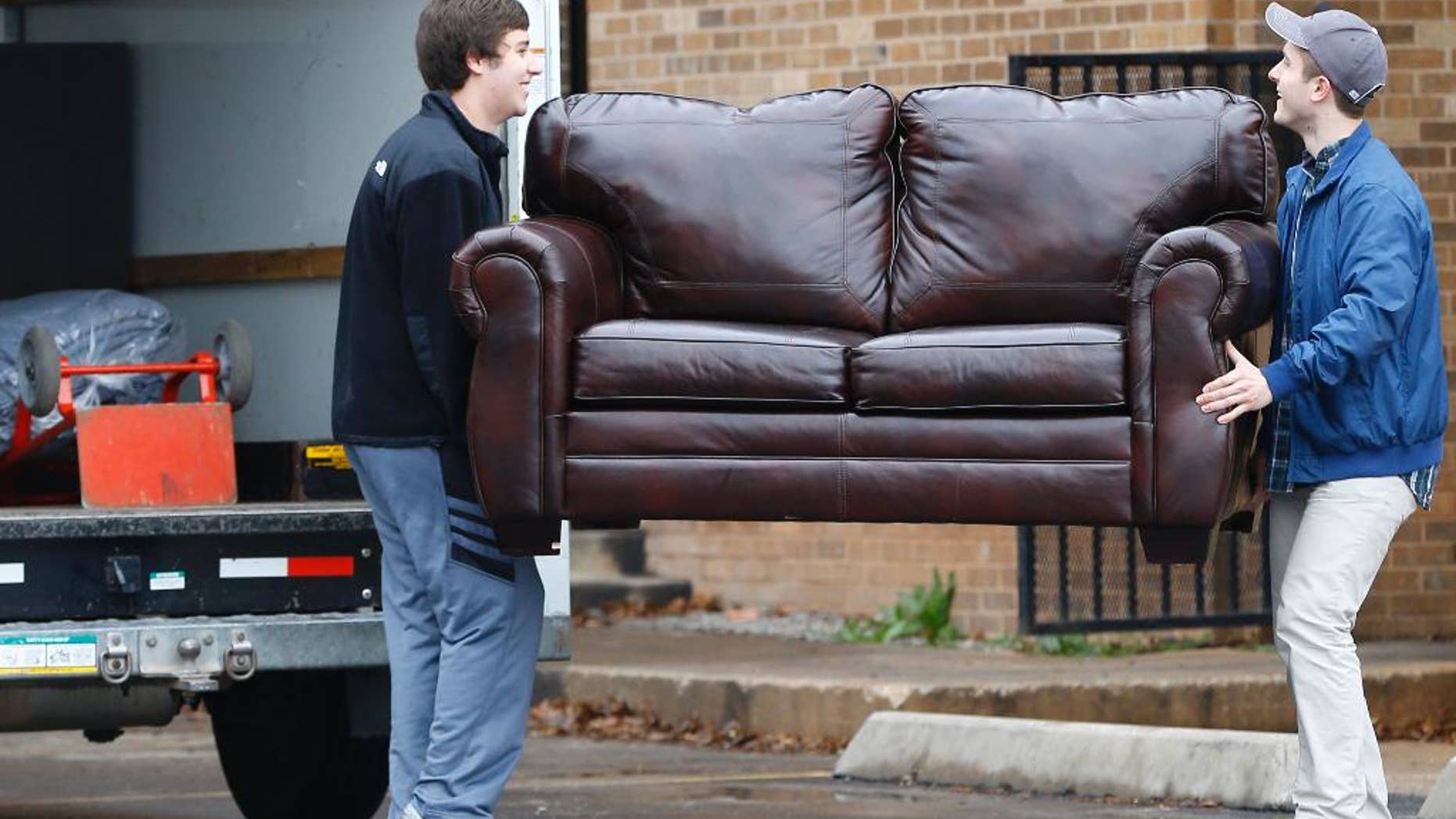 File-This March 10, 2015, file photo shows two men loading a couch from the now closed University of Oklahoma's Sigma Alpha Epsilon fraternity house into a moving truck, in Norman, Okla. Fraternities dominate social life at many American universities, but lately these organizations of male college students have been receiving unwanted attention for their bad behavior. At the University of Oklahoma, one prominent fraternity was shut down after members were caught on video performing a racist chant. (AP Photo/Sue Ogrocki, File)