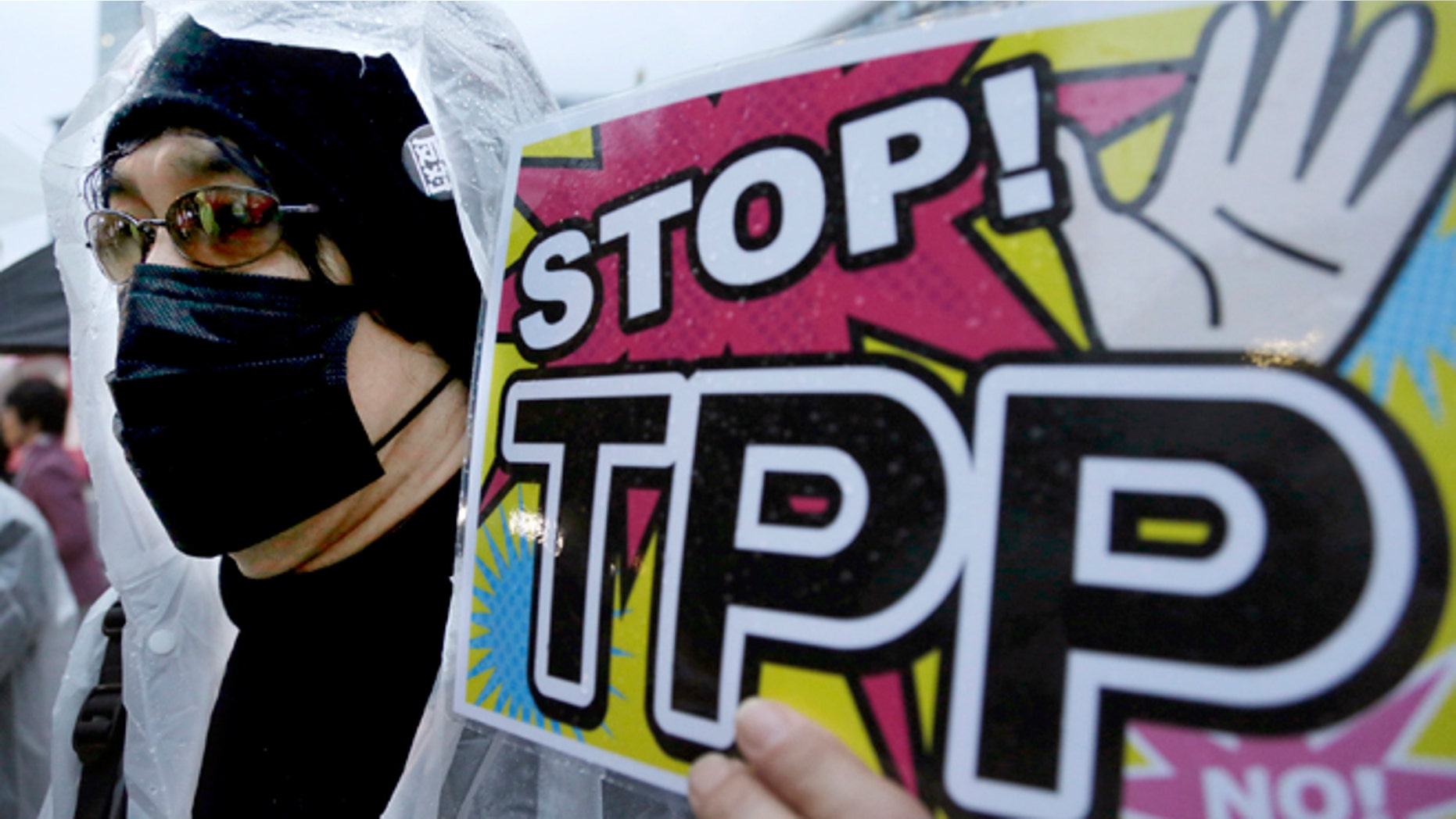 FILE - In this April 22, 2104 file photo, a protester holds a placard during a rally against the Trans-Pacific Partnership (TPP) in Tokyo. Just over two decades after lobbying unsuccessfully against the North American Free Trade Agreement, U.S. labor unions are again voicing strong reservations to a proposed major trade-liberalization deal. (AP Photo/Shizuo Kambayashi, File)