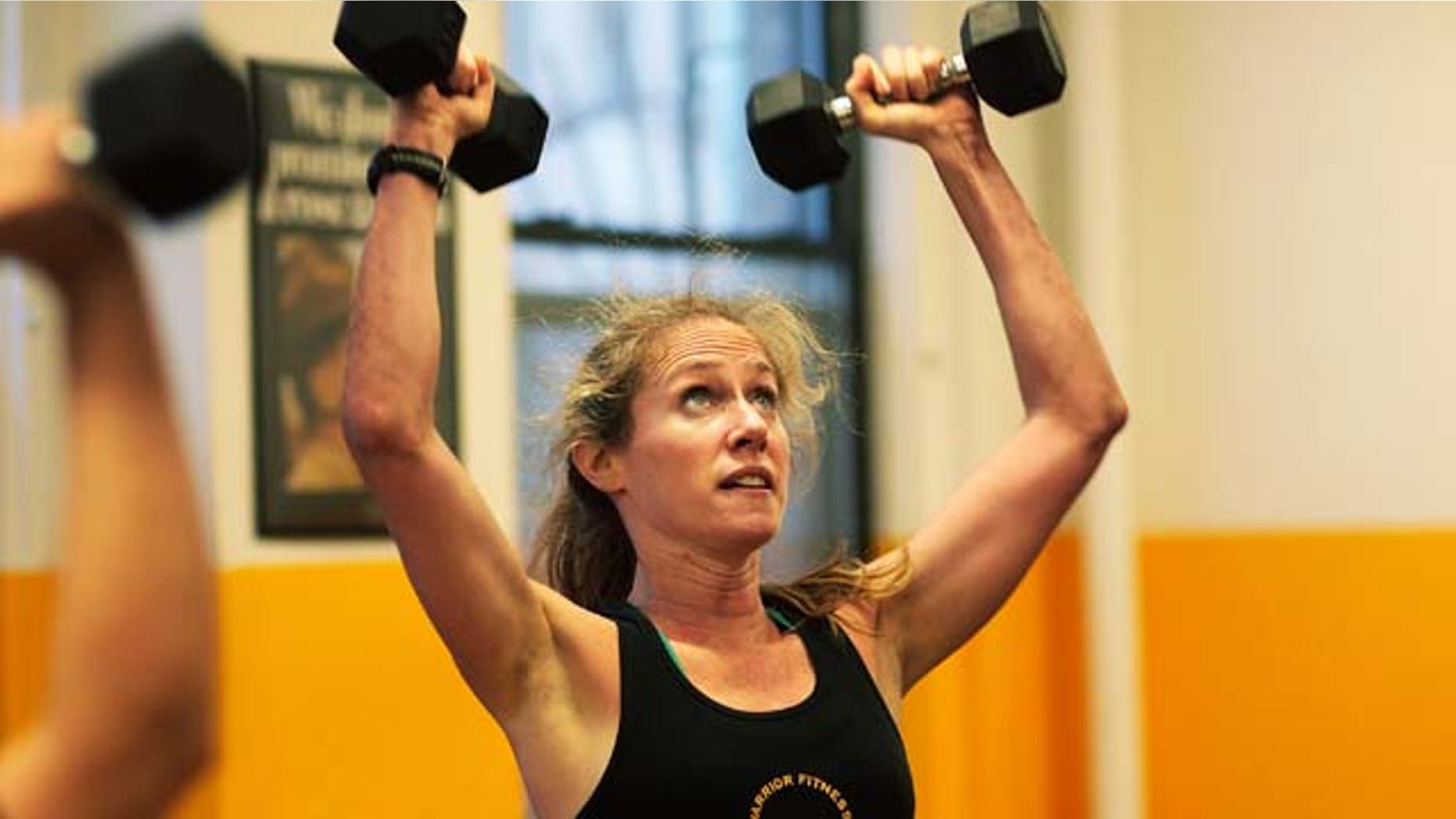 MARCH 17: A woman lifts dumbells during a workout at Warrior Fitness Boot Camp gym March 17, 2009 in the Midtown neighborhood of New York City. (Photo by Chris Hondros/Getty Images)