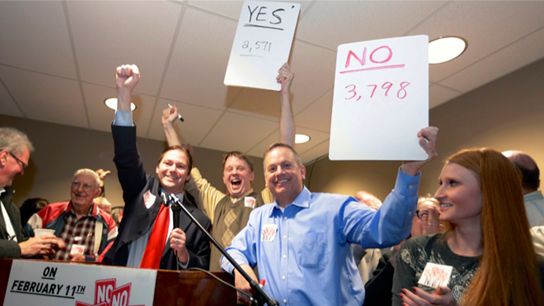 FILE - In this file photo from Feb. 11, 2014, State Sen. Charlie Jansssen of Fremont, third left, Jeremy Jensen, center, and John Wiegert, second right, celebrate in Fremont, Neb., after city voters have decided by voting no, to uphold the law designed to bar immigrants from renting homes if they dont have legal permission to be in the U.S. On Monday, May 5, 2014, the U.S. Supreme Court decided not to review Fremont's ordinance that bans renting homes to immigrants living in the country illegally. Supporters of the ordinance said it could open the door to similar laws elsewhere. (AP Photo/Nati Harnik, File)