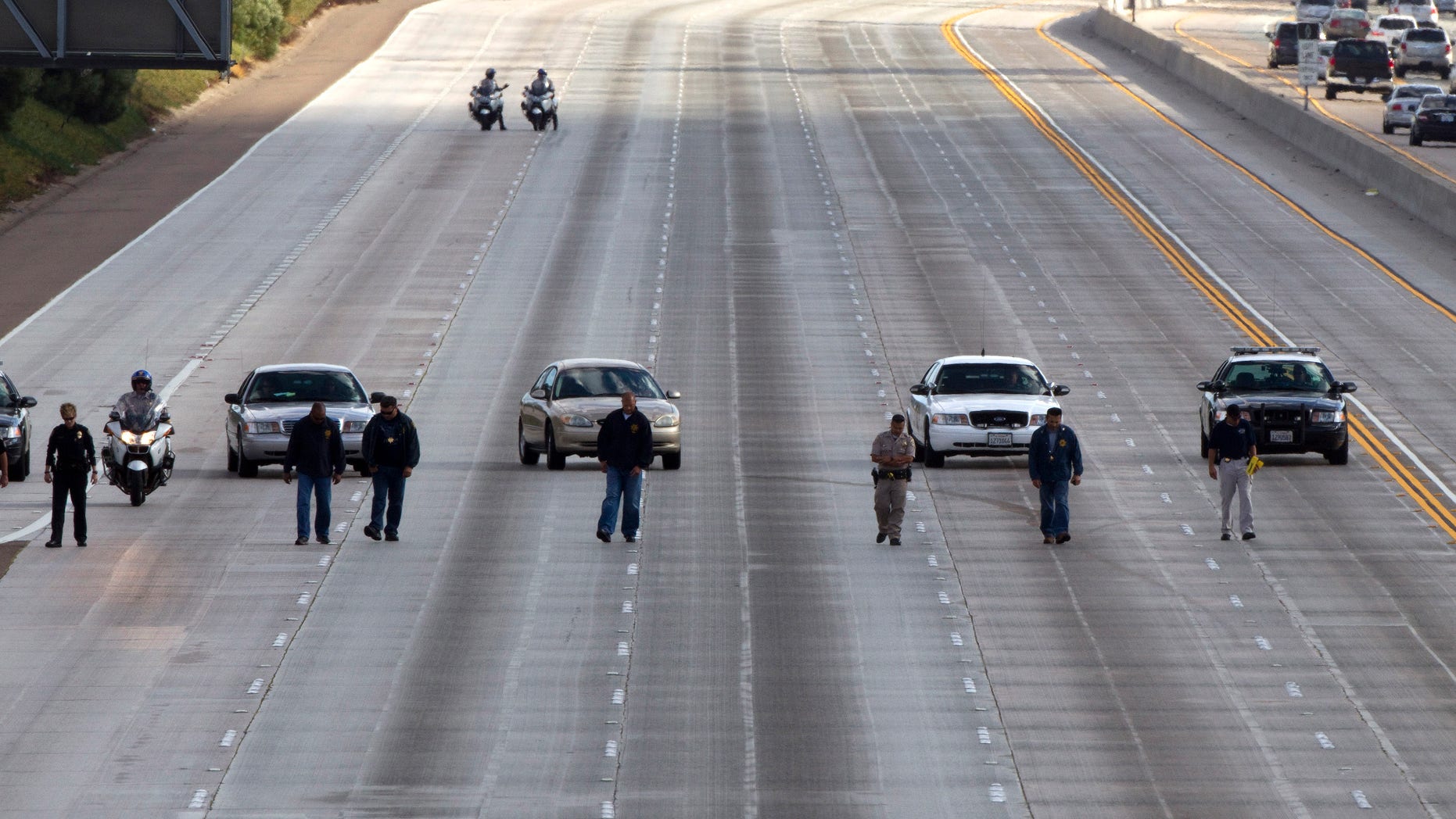 October 3: Law enforcement personal look for evidence on 5 north the 805 and south of Del Mar Heights Road in a string of shootings on Interstates 805 and 5 in Del Mar, California.