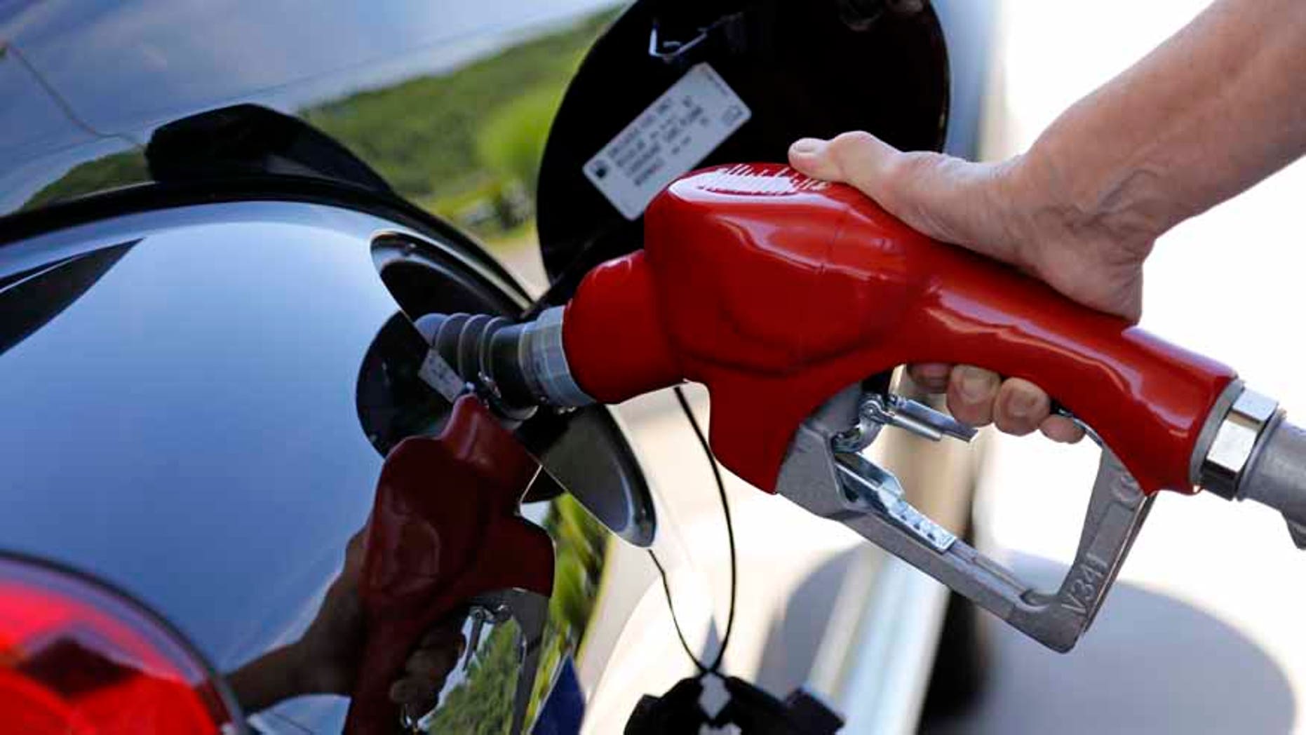 In this Thursday, July 16, 2015, photo, a customer re-fuels her car at a Costco in Robinson Township, Pa. The U.S. government says the fuel economy of the nations fleet of cars and trucks likely wont meet its targets in 2025 because low gas prices have changed the types of vehicles people are buying. (AP Photo/Gene J. Puskar)