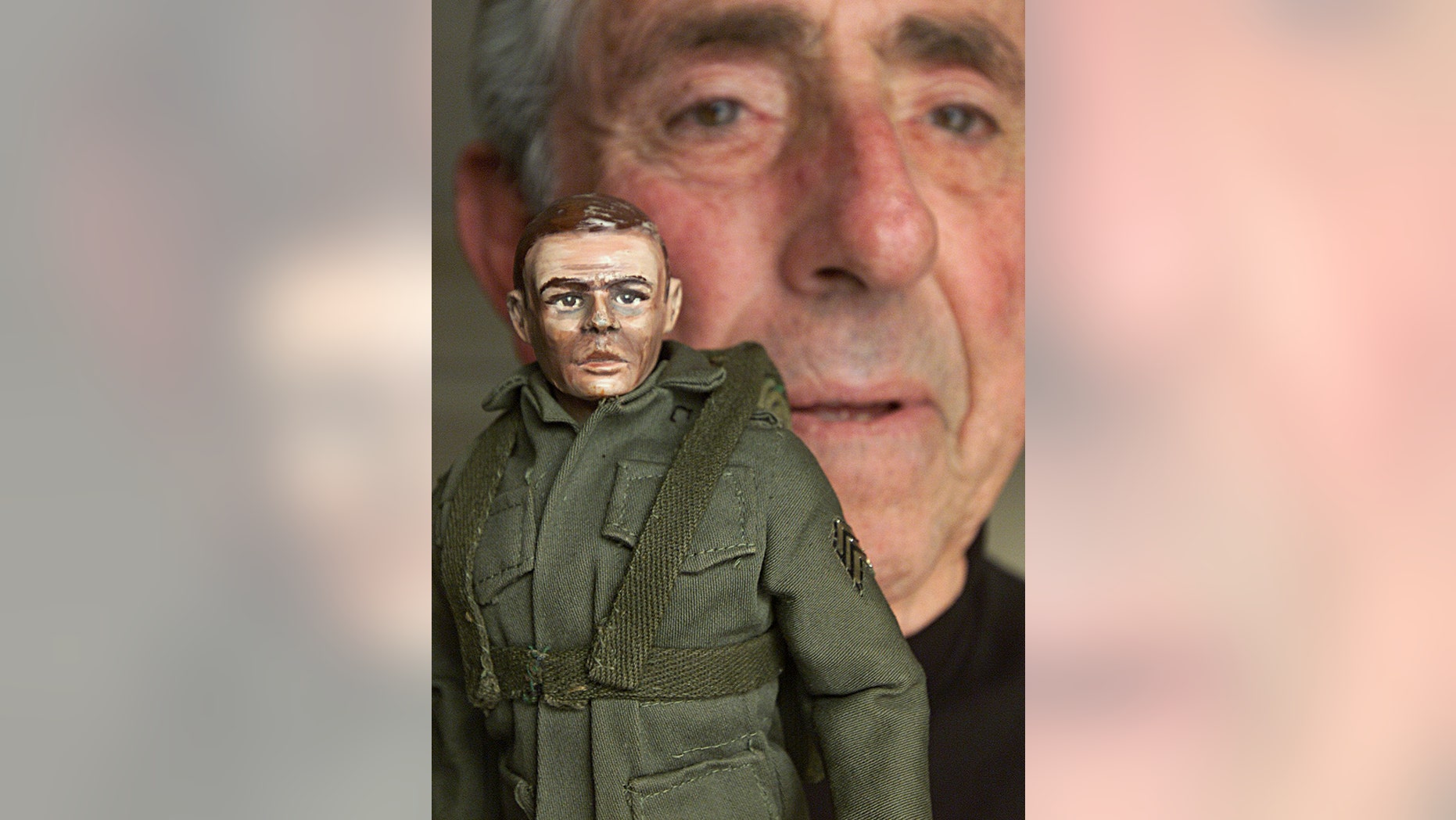 Jan. 30, 2003 file photo, G.I. Joe creator Don Levine holds up his original hand-carved, hand-painted G.I. Joe prototype in Providence, R.I. Levine died of cancer early Thursday, May 22, 2014. He was 86.