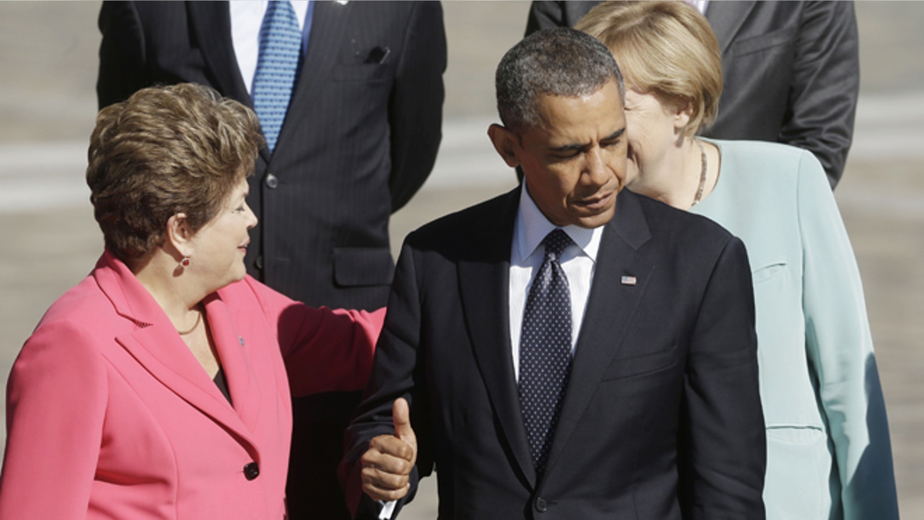 US President Barack Obama, right, gives a 'thumbs-up' sign as he waits with other leaders for Russia's President Vladimir Putin to take the group photo at the G-20 summit at the Konstantin Palace in St. Petersburg, Russia, Friday, Sept. 6, 2013. Greeting each other behind Obama are Brazil's President Dilma Rousseff, left, and Germany's Chancellor Angela Merkel. (AP Photo/Pablo Martinez Monsivais)