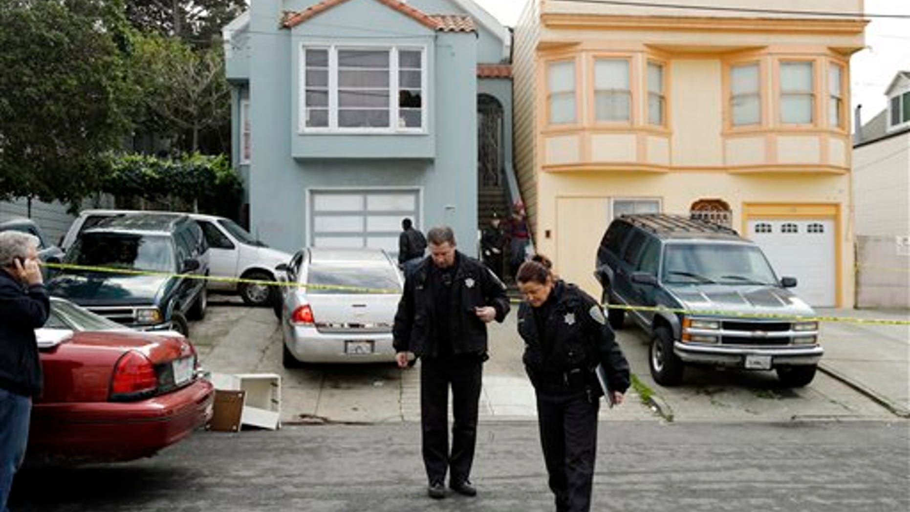 Jan. 6, 2013: San Francisco police officers search for evidence and guard the home of a woman who was set on fire.