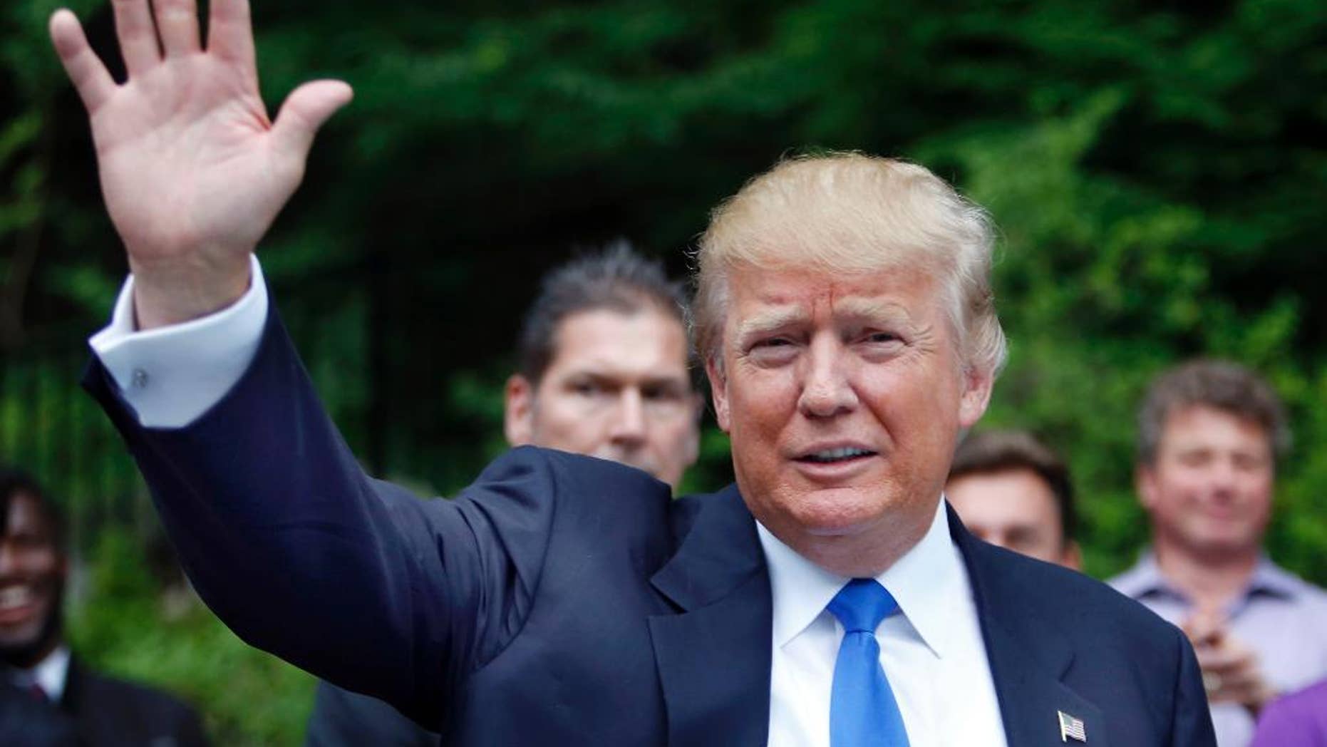 In this June 30, 2015, photo, Republican presidential candidate Donald Trump waves as he arrives at a house party in Bedford, N.H. Hispanic leaders are warning of harm to Republican White House hopes unless the party’s presidential contenders do more to condemn Trump, who’s refusing to apologize for calling Mexican immigrants rapists and drug dealers. (AP Photo/Jim Cole)