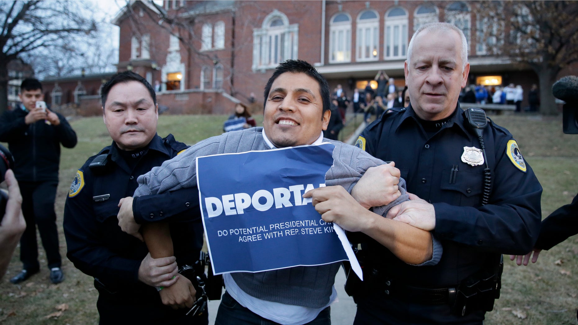 Marco Malagon is removed from the venue by Des Moines police officers after protesting during former Texas Gov. Rick Perry's speech at the Freedom Summit, Saturday, Jan. 24, 2015, in Des Moines, Iowa. (AP Photo/Charlie Neibergall)
