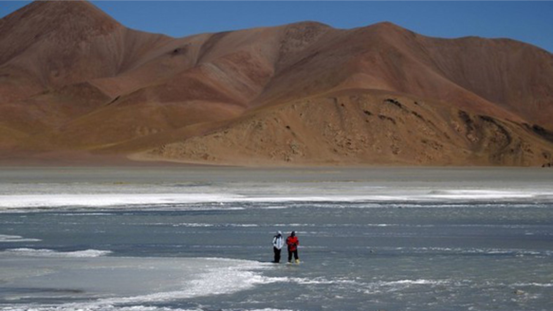 Microbiologist Maria Eugenia Farias (R) and an aide look for rock samples containing bacteria in the crater of the Galan Volcano, at over 15,400 feet above sea level in Catamarca August 4, 2010.