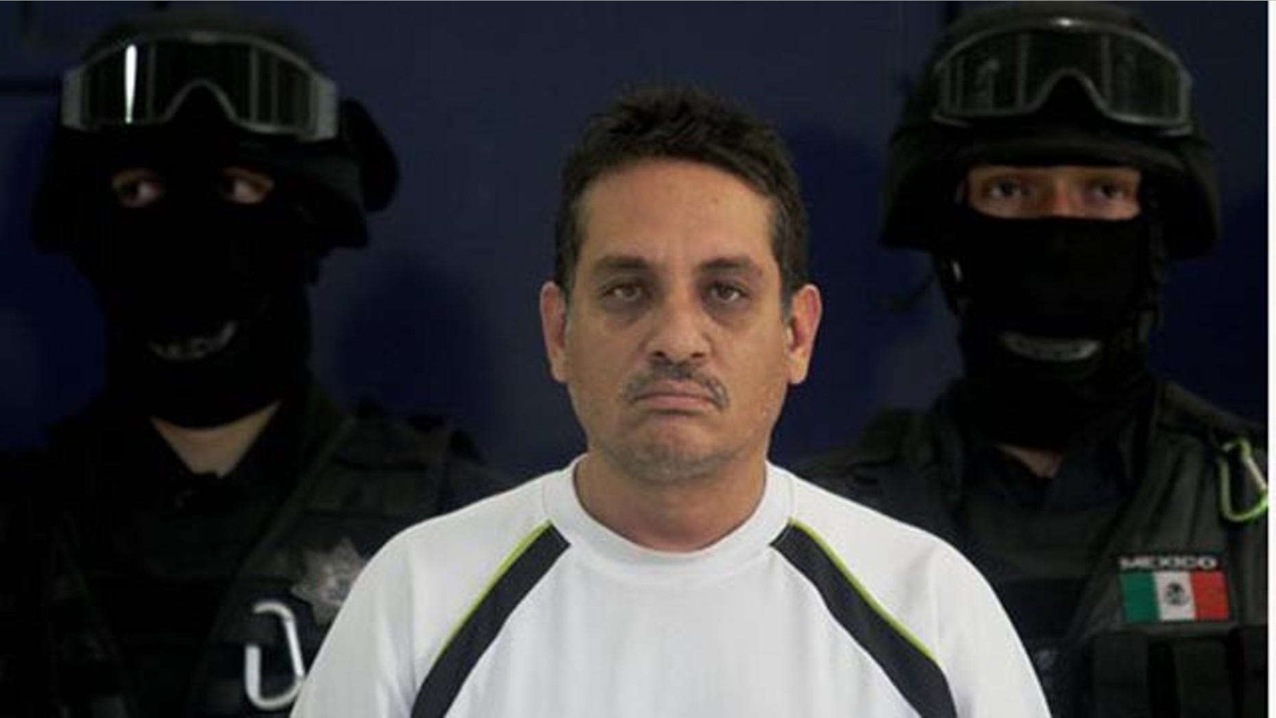 July 2, 2010: Jesus Ernesto Chavez, known as "El Camello" stands as he is guarded by federal police officers during a presentation to the press, in Mexico City. According to the federal police Chavez ordered the March 13 attack that killed a U.S. consulate employee and her husband as they drove in the violent border city.