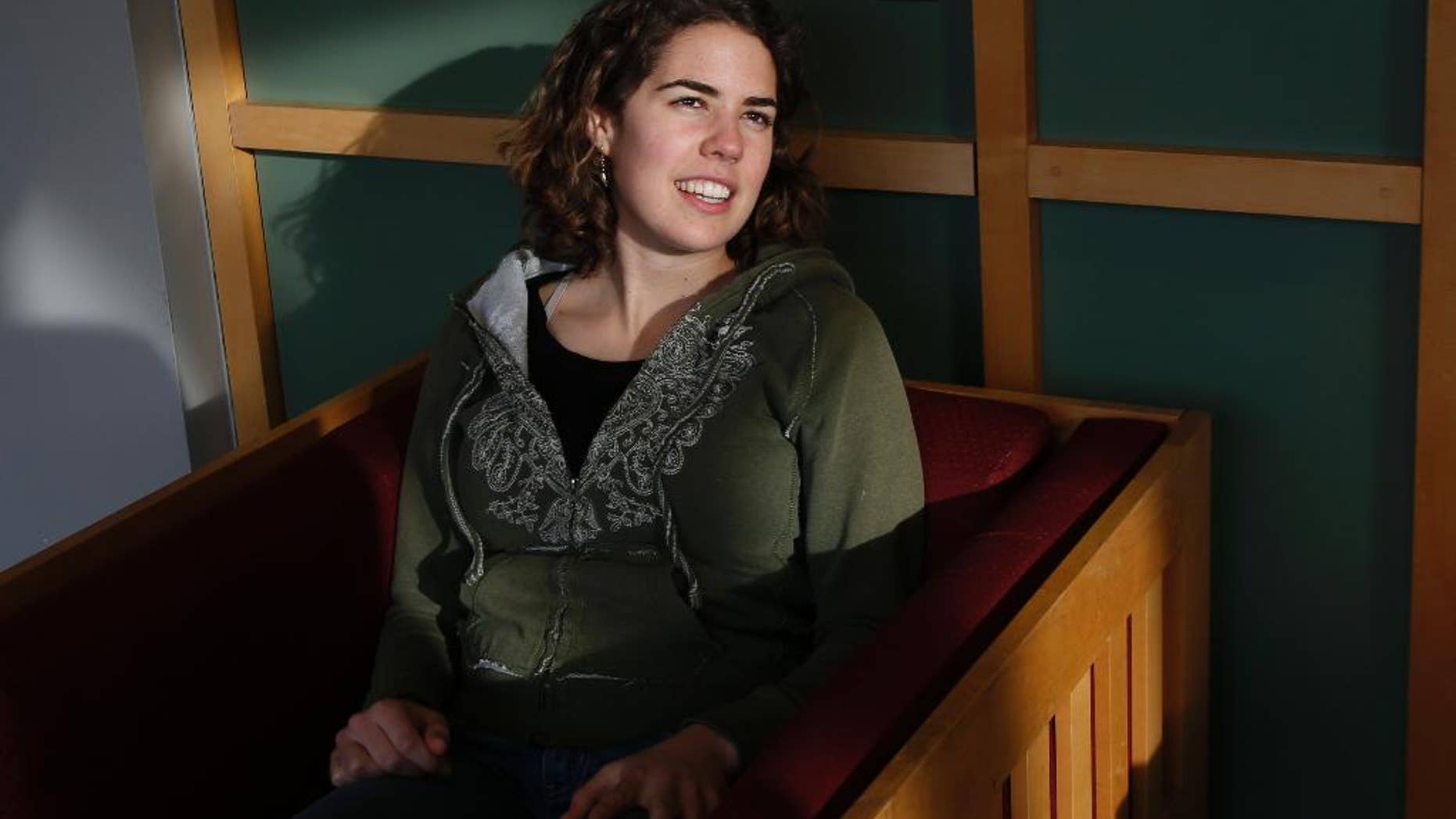 Freshman Lydia Collins, 19, chats with a friend in a lounge at Tufts University in Medford, Mass., Thursday, March 13, 2014. Collins took a year after high school and worked in Ecuador through Global Citizen. Tufts is starting its own program, hoping to remove the financial barriers that keep cash-strapped students from taking a year off after high school to travel or volunteer, and thereby offer an opportunity now typically only available to more affluent students to explore different communities and challenge their comfort zones before starting college. This “gap year” program launching this fall will pay for housing, airfare and even visa fees, which can add up to $30,000 or more. (AP Photo/Elise Amendola)