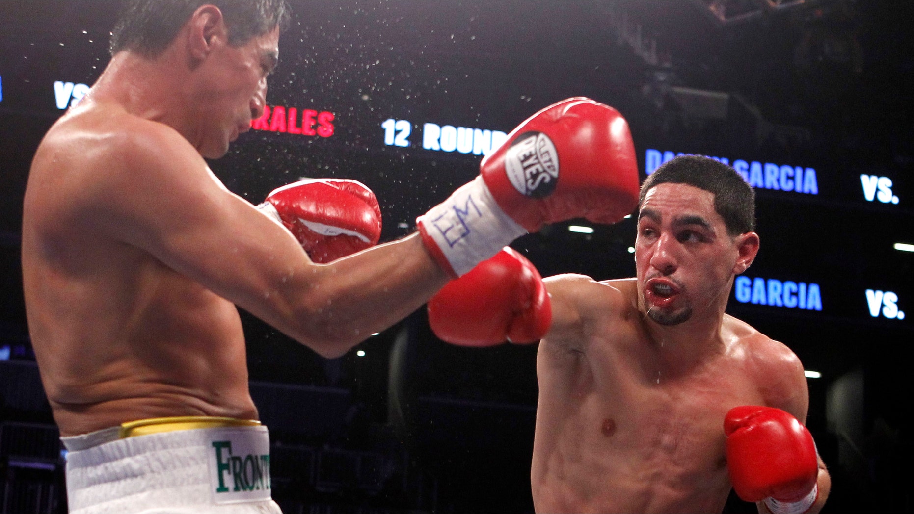 Danny Garcia, right, punches Mexico's Erik Morales during their WBC and WBA super lightweight title bout at the Barclays Center, Saturday, Oct. 20, 2012, in New York. Garcia knocked out Morales in the fourth round. (AP Photo/Jason DeCrow)