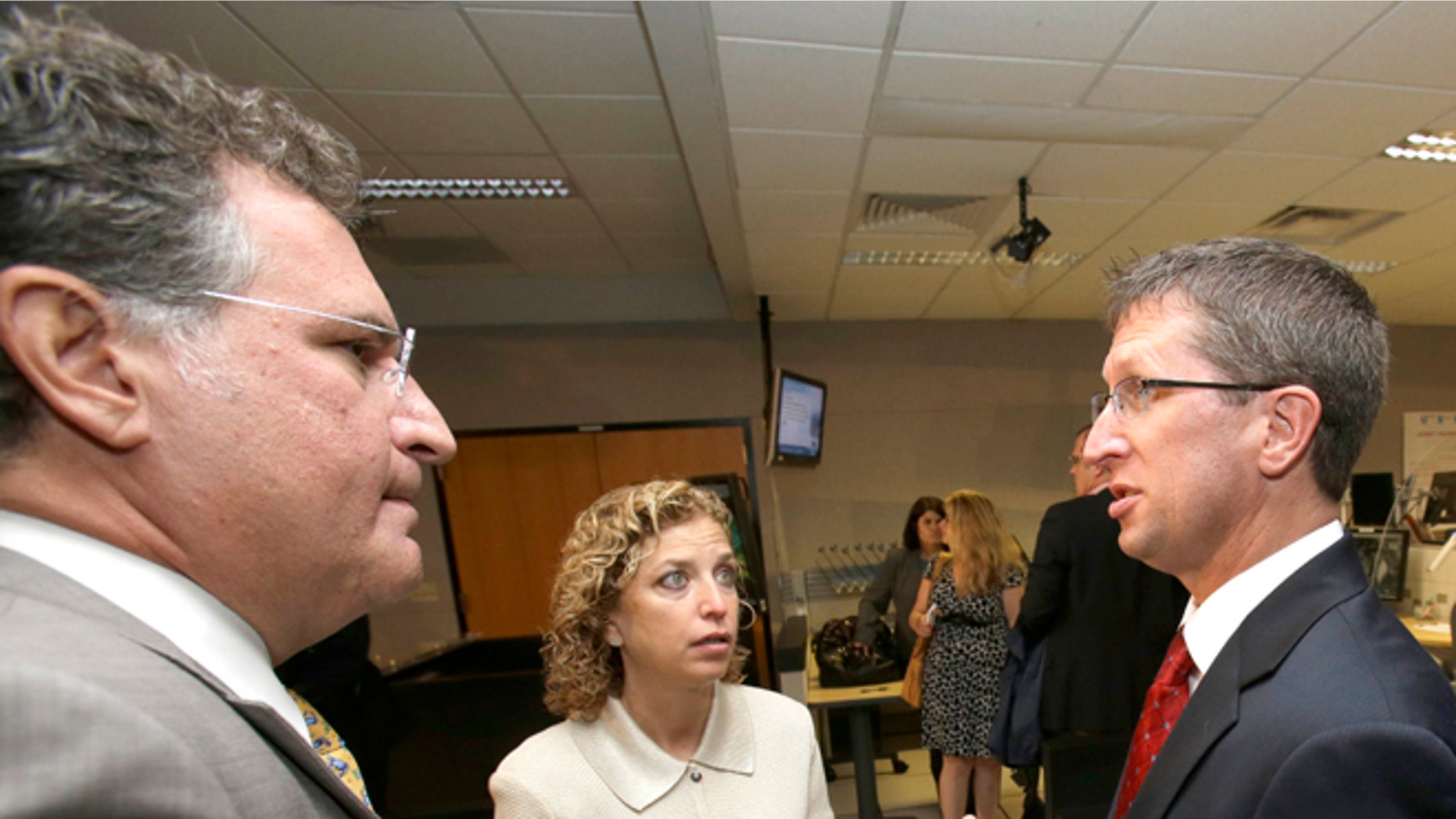 FILE: May 31, 2013: Rep Joe Garcia, D-Fla., with Rick Knabb, National Hurricane Center director, and Rep. Debbie Wasserman Schultz, D-Fla., at the National Hurricane Center in Miami, Fla.