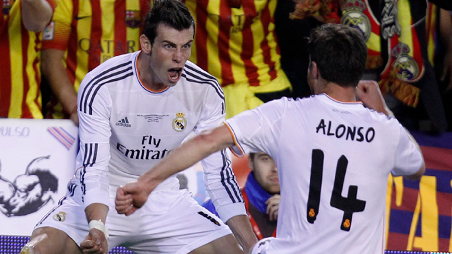 Real's Gareth Bale, left celebrates with Xabi Alonso after scoring his team's 2nd goal during the final of the Copa del Rey between FC Barcelona and Real Madrid at the Mestalla stadium in Valencia, Spain, Wednesday, April 16, 2014. (AP Photo/Alberto Saiz)