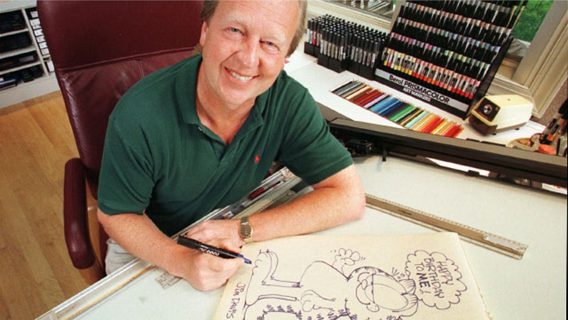 FILE - In this June 9, 1998 file photo, Garfield creator Jim Davis pauses after drawing the cartoon character in his Muncie, Ind., office.