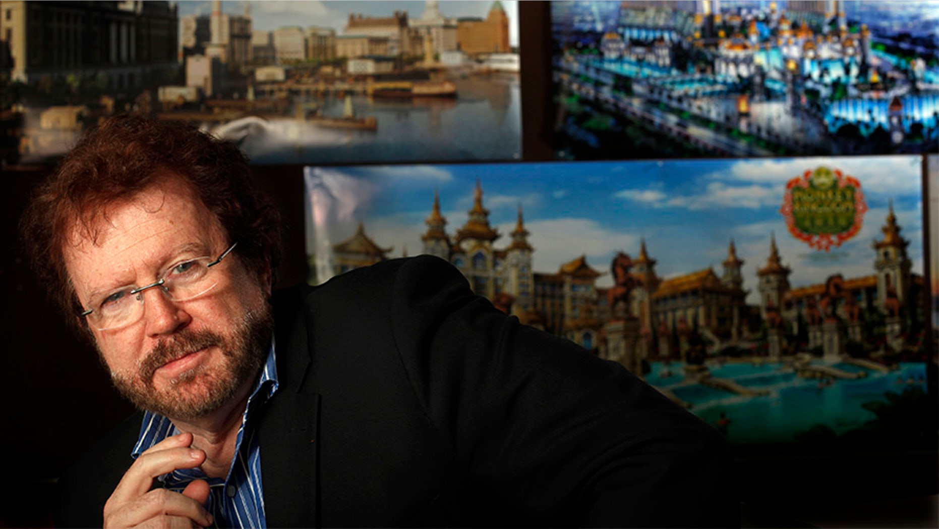 NORTH HOLLYWOOD, CA - JANUARY 15, 2015: Gary Goddard Entertainment founder, Gary Goddard, in his North Hollywood office meeting room with posters of projects he has working in China on JANUARY 15, 2015. Gary Goddard Entertainment is among many Southern California theme park design businesses that have been getting work in China thanks to a surge in demand for leisure activities in Asia. The posters left to right top row show: the Hengdian Studios recreation of the Shanghai Bund, and the Galaxy Theme Park in Macau and the lower one, the Monkey Kingdom theme park, currently being constructed. (Photo by Bob Chamberlin/Los Angeles Times via Getty Images)