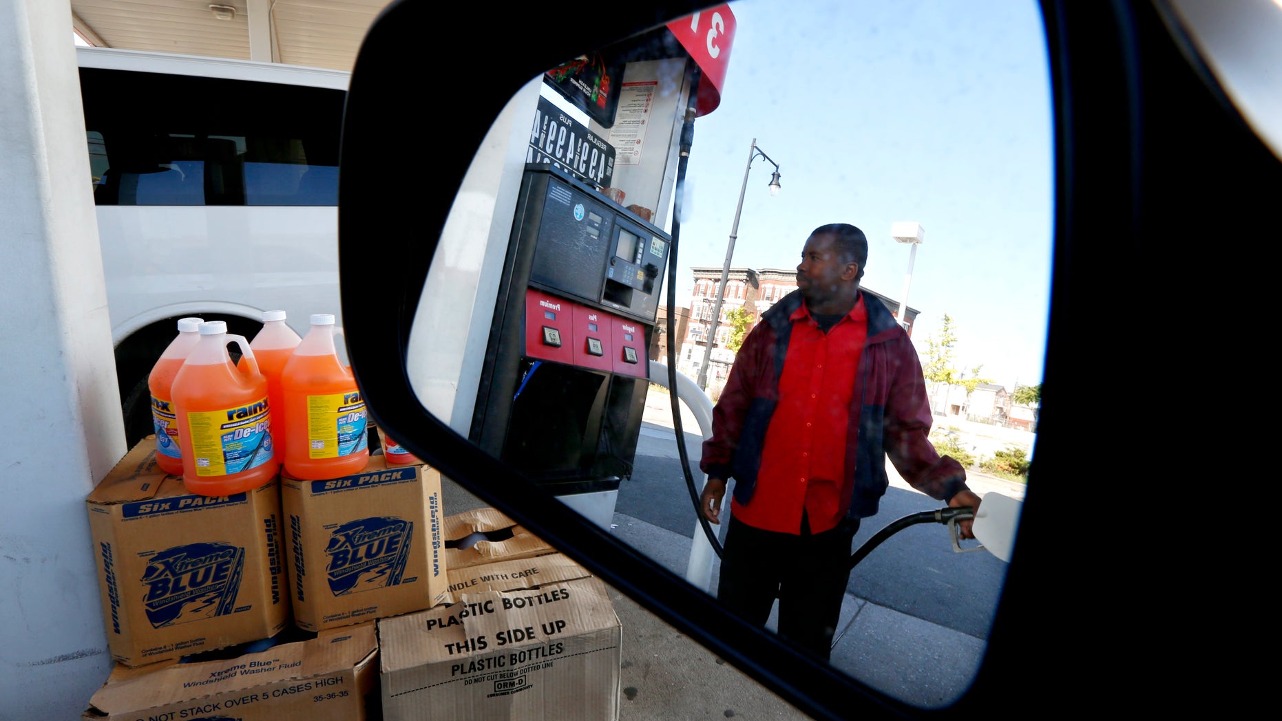 Gas station attendant Youssouf Soukouna, 42, pumps gas into a vehicle at a LukOil station where all levels of gas were priced at $4.99, Wednesday, Sept. 12, 2012, in Newark, N.J. Soukouna, who has worked at the station for 12 years, said he has never seen prices these high. More than 50 LukOil franchise owners plan to raise their prices to more than $8 a gallon on Wednesday to protest what they say is the company's unjustified pricing policies. (AP Photo/Julio Cortez)
