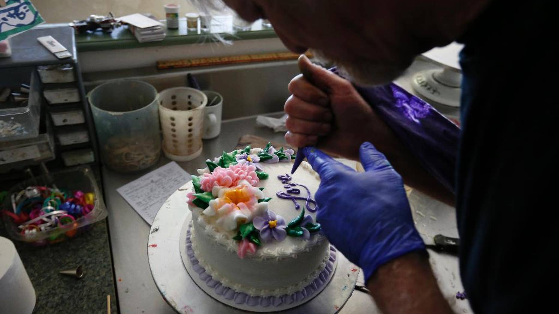 In this March 10, 2014 photo, Masterpiece Cakeshop owner Jack Phillips decorates a cake inside his store, in Lakewood, Colo. Phillips is appealing a recent ruling against him in a legal complaint filed with the Colorado Civil Rights Commission by a gay couple he refused to make a wedding cake for, based on his religious beliefs. (AP Photo/Brennan Linsley)