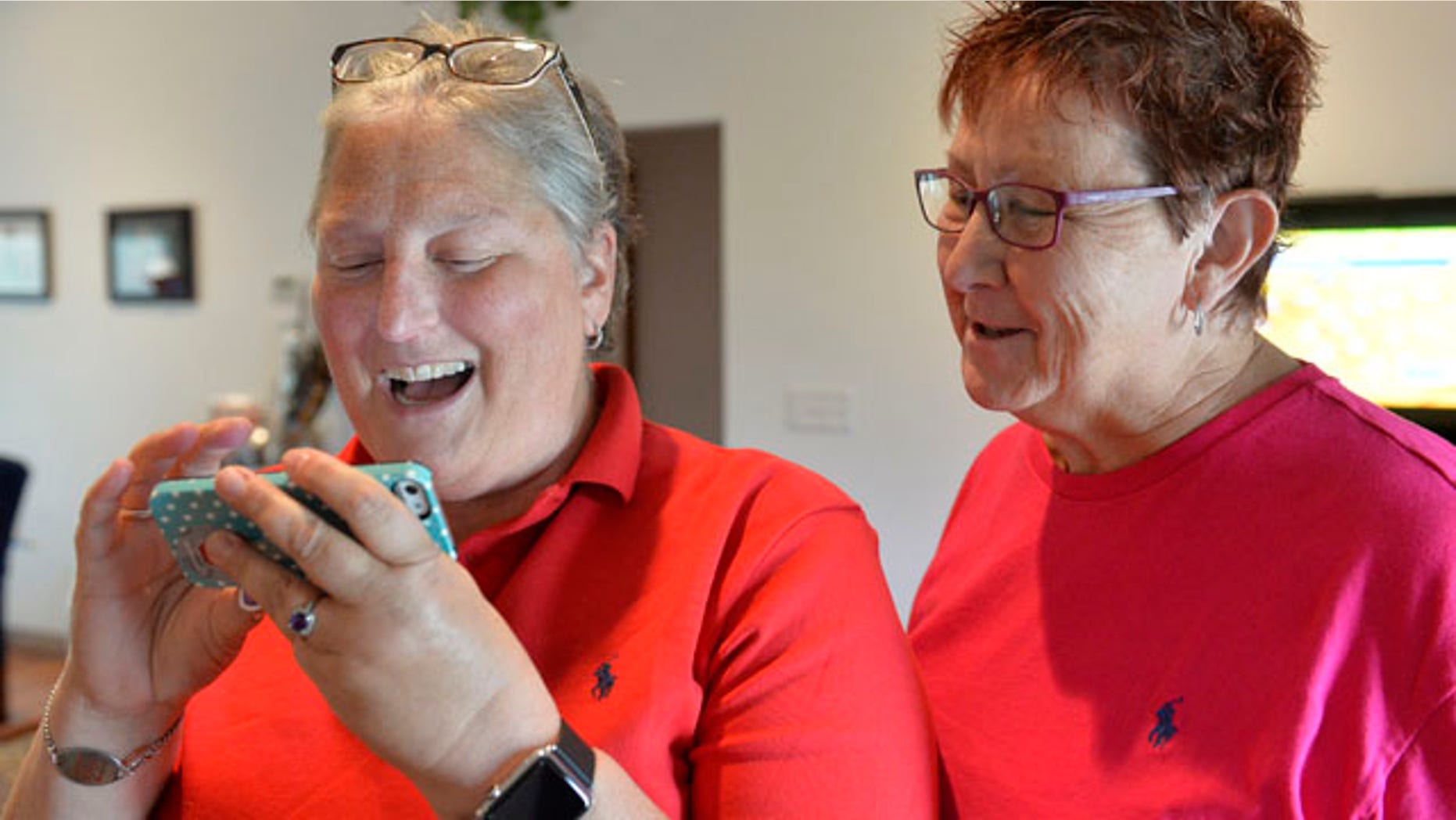 Aug. 26, 2015: April Miller, left, and her partner Karen Roberts read the decision of the United States Sixth Circuit Court of Appeals refusing to hear Rowan County Clerk Kim Davis' appeal that ordering her to issue marriage licenses is against her religious beliefs in Morehead, Ky. (AP Photo/Timothy D. Easley)