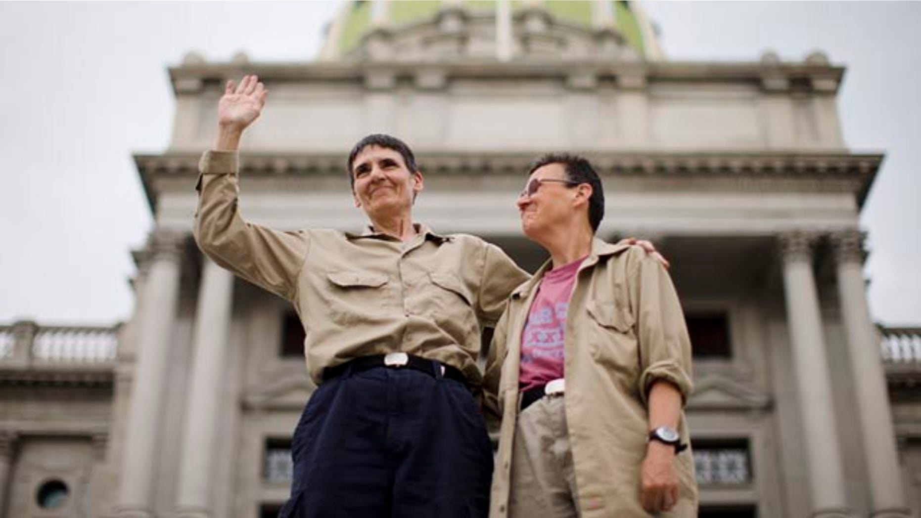 May 20 ,2014: Julie Lobur, left, and Marla Cattermole look out on supporters of gay marriage at a rally on the steps of the state Capitol. (AP Photo/Matt Rourke)