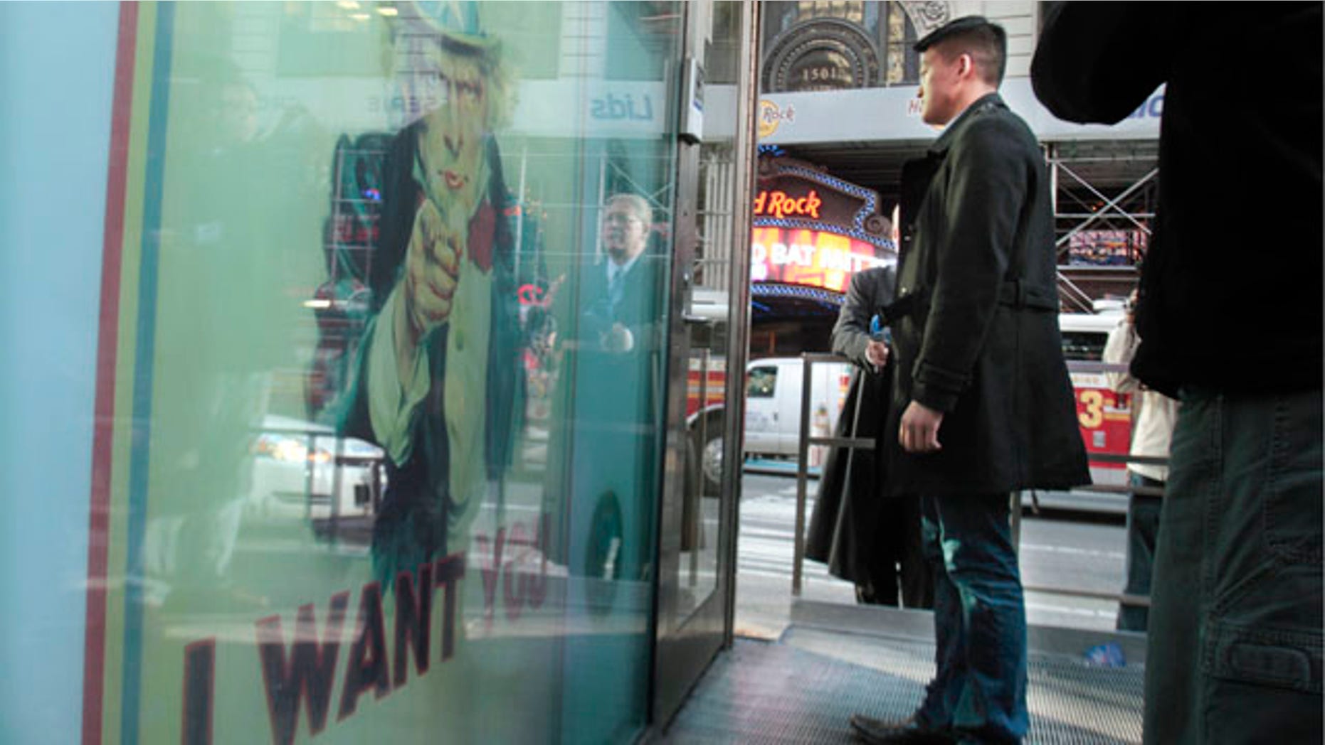 Oct. 19: Dan Choi, center, an Iraq War veteran and a West Point graduate who was discharged from the military in July because he announced publicly that he is gay, stands waiting at the door of the U.S. Armed Forces Recruiting Center in Times Square hoping to re-enlist.