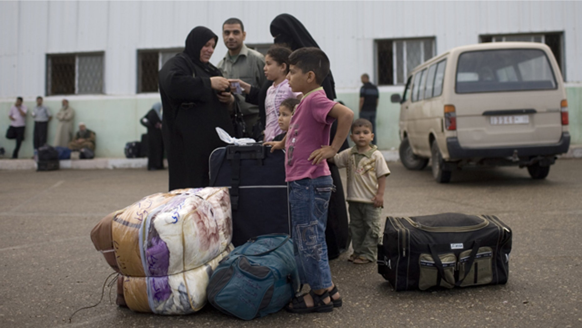 May 28, 2011: A Palestinian family waits before crossing into Egypt through the Rafah border crossing, southern Gaza Strip. After four years, Egypt on Saturday permanently opened the Gaza Strip's main gateway to the outside world, bringing long-awaited relief to the territory's Palestinian population and a significant achievement for the area's ruling Hamas militant group.