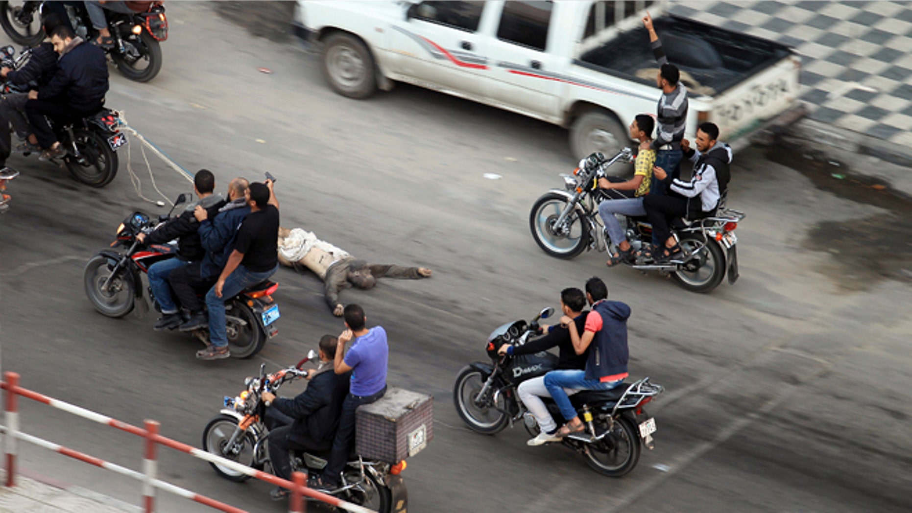 Nov. 20, 2012: Palestinian gunmen ride motorcycles in Gaza City as they drag the body of a man who was suspected of working for Israel.