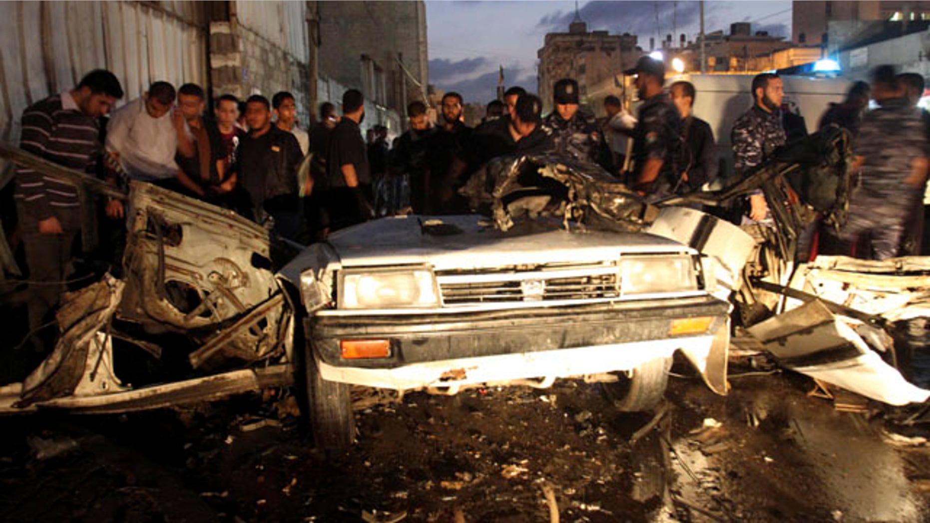Nov. 17: Palestinians gather around a destroyed car after an explosion in Gaza City.