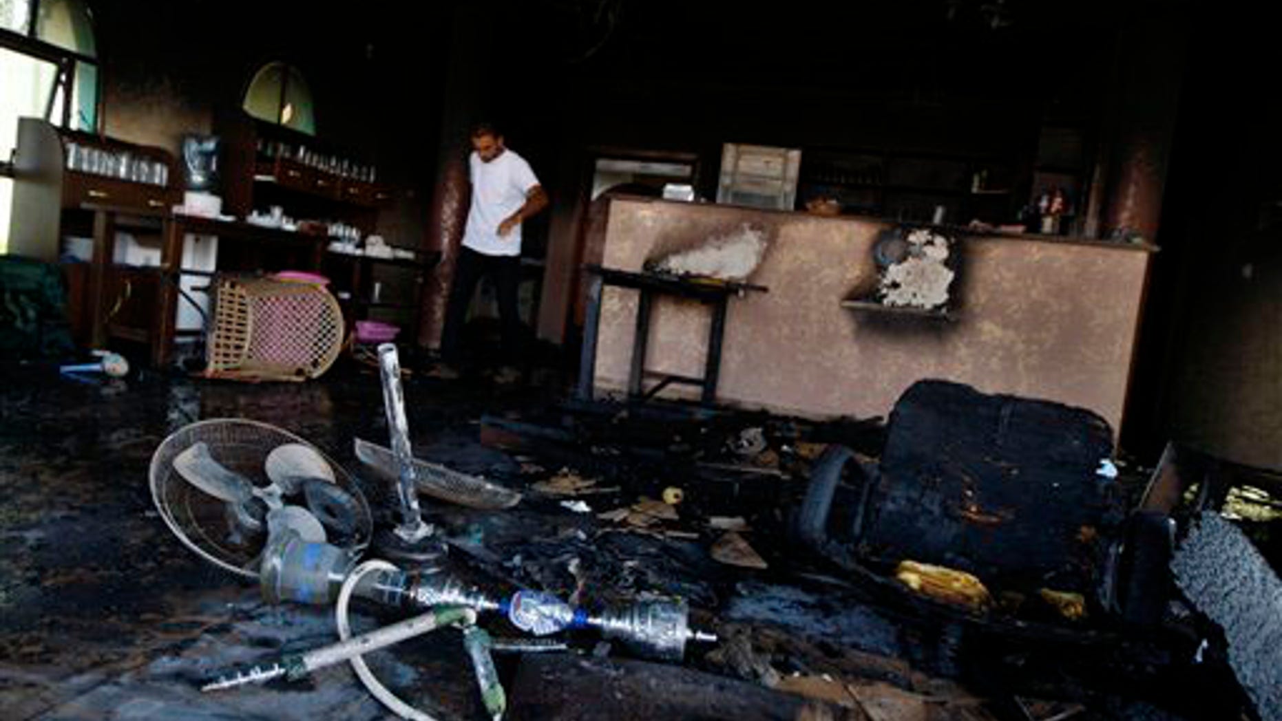 A Palestinians man checks the damage at a water amusement park after it was set on fire in Gaza City, Sunday, Sept. 19, 2010. A Gaza amusement park accused of allowing men and women to sit together has been burnt down. The park, which serves the territory's small elite, was shuttered by Hamas in August after men and women were seen mixing together.