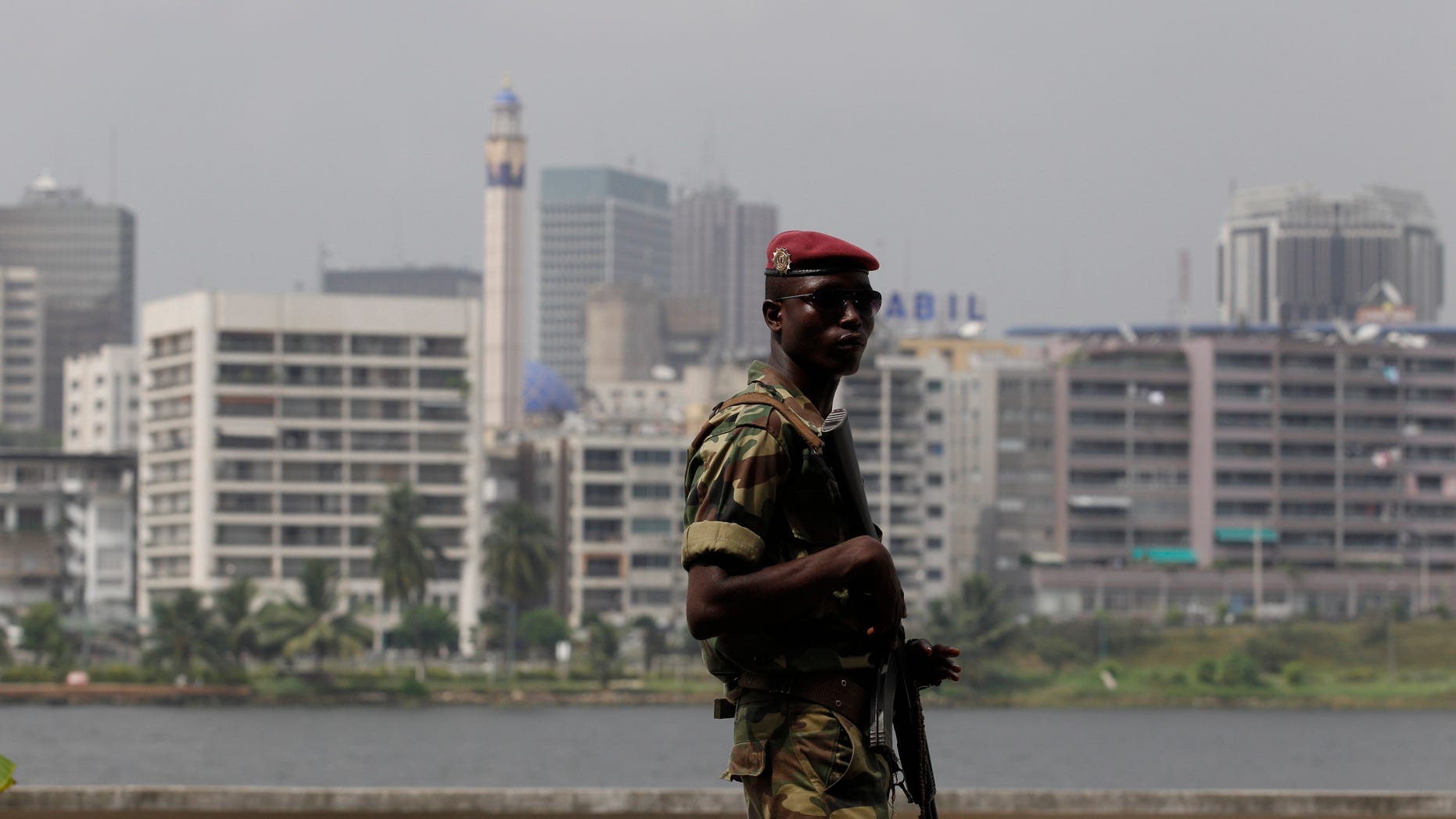 Jan. 9, 2011: Against a backdrop of Abidjan's central Plateau district, a soldier provides security at a rally in support of incumbent president Laurent Gbagbo, at the Palace of Culture in Abidjan, Ivory Coast. Former Nigerian President Olusegun Obasanjo was shuttling between meetings Sunday with the country's defiant president who refuses to cede power and the internationally recognized winner in the latest effort to resolve the post-election crisis. (AP)