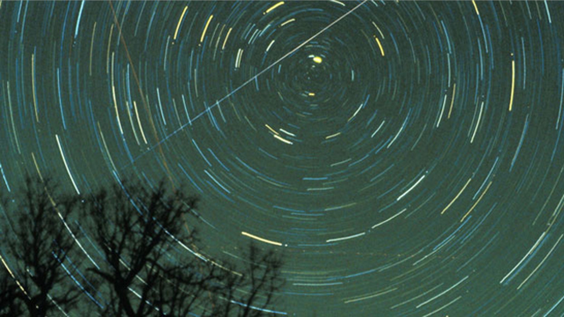 A Geminid meteor streaks across the sky.