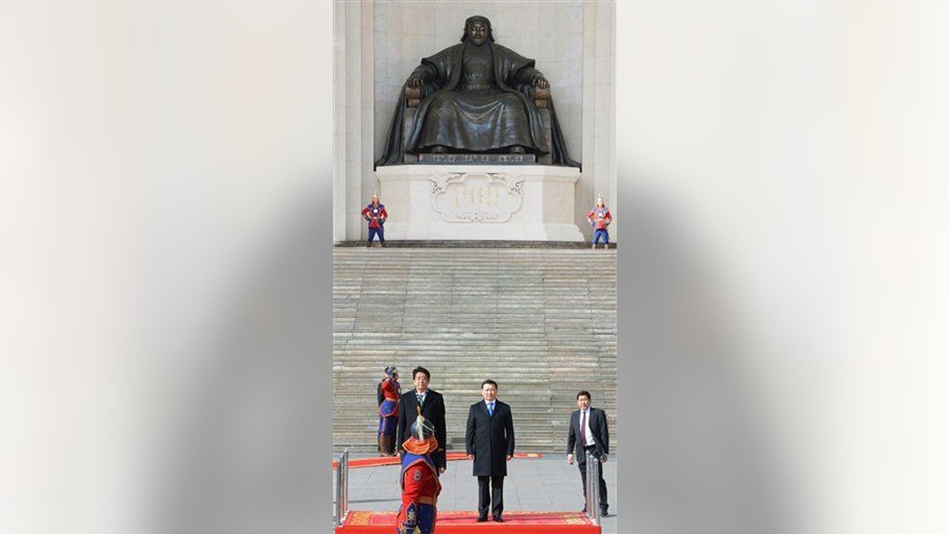 With a backdrop of a giant statue of the Mongol Empire founder Genghis Khan, Japanese Prime Minister Shinzo Abe, standing left on the podium, accompanied by his Mongolian counterpart Norov Altankhuyag, attends welcome ceremony after his arrival for a two-day visit in Ulan Bator, Mongolia, Saturday, March 30, 2013. Abe was the first Japanese leader to visit the North Asian country in almost seven years.