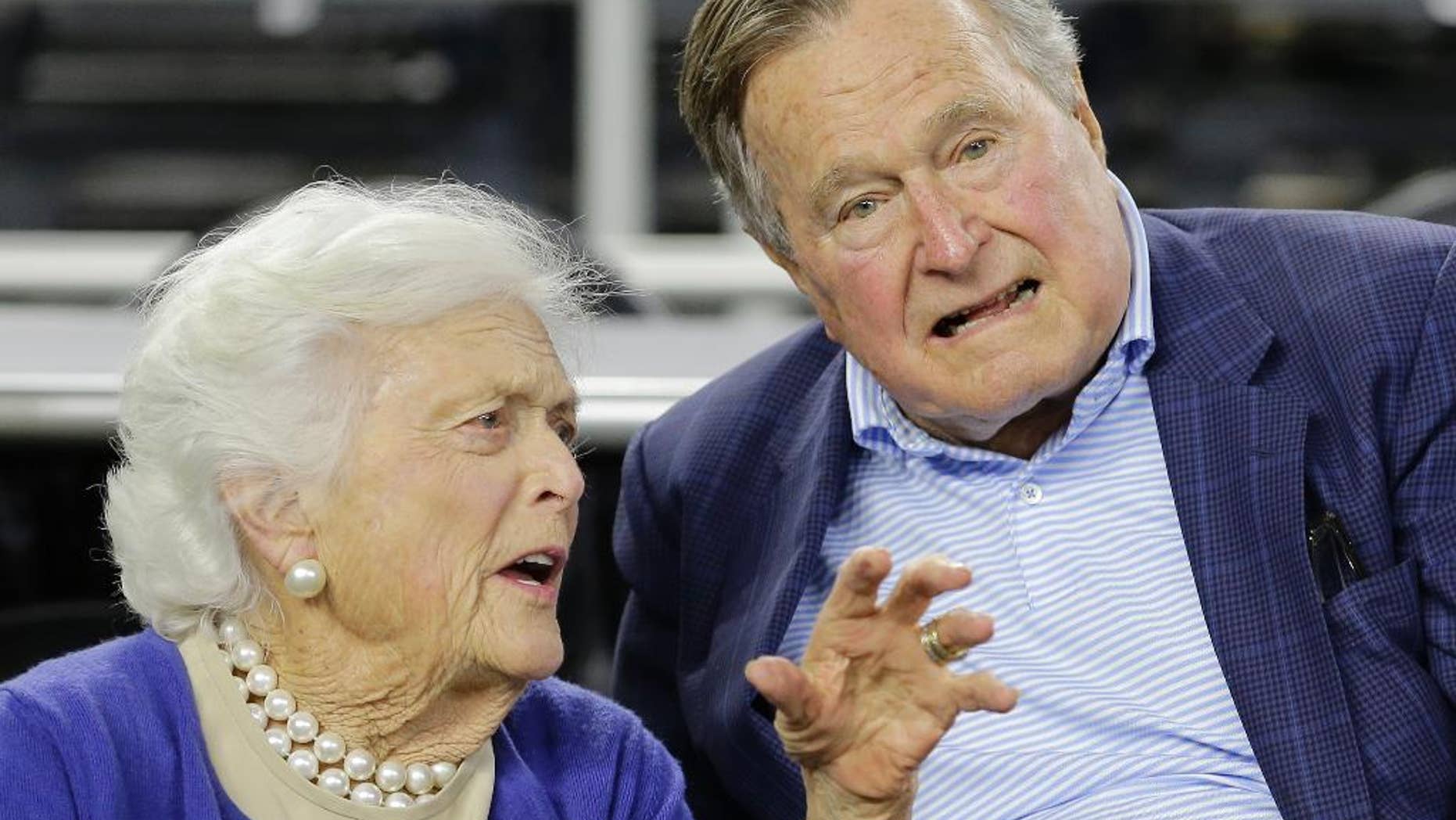 FILE- In this March 29, 2015, file photo, former President George H.W. Bush and his wife Barbara Bush speak before the first half of an NCAAA college basketball game in Houston. A spokesman says doctors are pleased with the progress the former president is making since he fractured a bone in his neck during a fall. Jim McGrath said Sunday, July 19, 2015, that Bush is doing better and his spirits are good. (AP Photo/David J. Phillip, File)