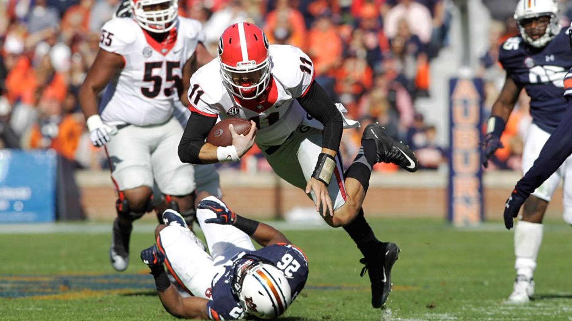 Nov 14, 2015; Auburn, AL, USA; Georgia Bulldogs quarterback Greyson Lambert (11) stumbles past Auburn Tigers corner back Devin Gillespie (26) during the third quarter at Jordan Hare Stadium. The Bulldogs beat the Tigers 20-13. Mandatory Credit: John Reed-USA TODAY Sports