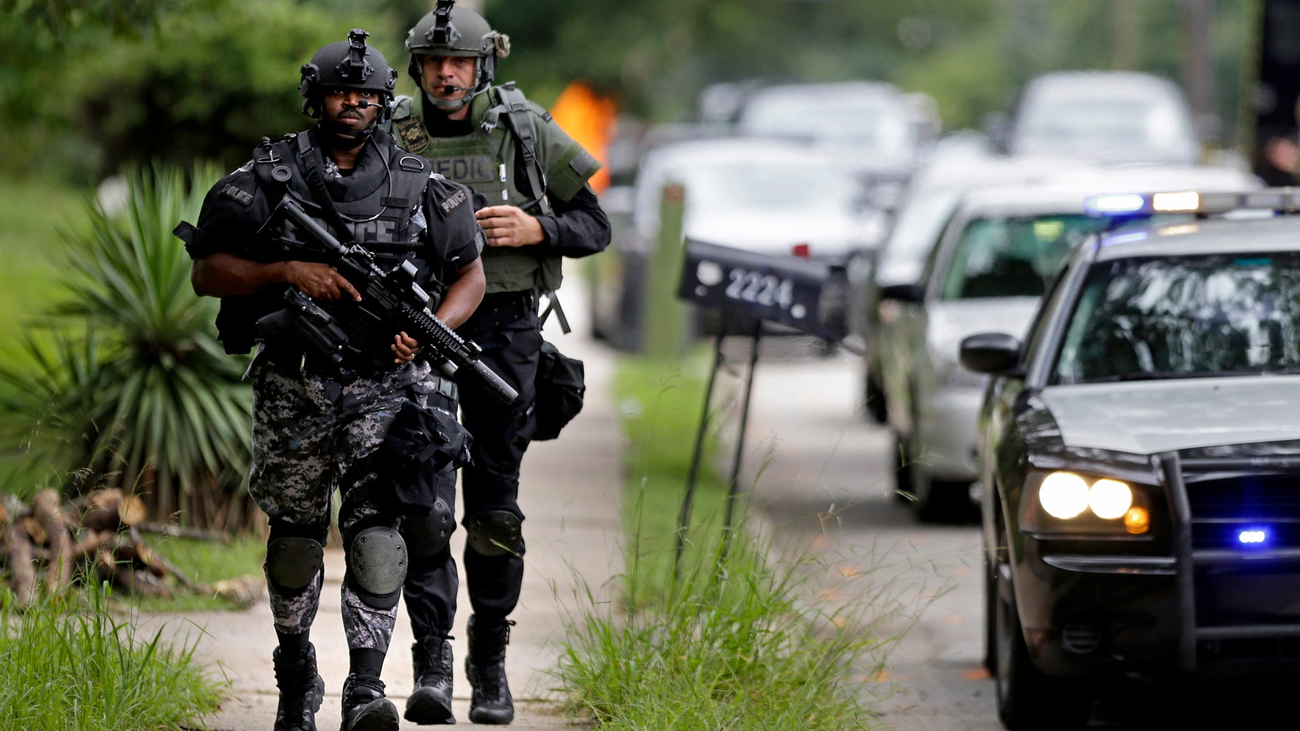 Dekalb County Police SWAT officers run toward Ronald E. McNair Discovery Learning Academy after reports of a gunman entered the school, Tuesday, Aug. 20, 2013, in Decatur, Ga. Superintendent Michael Thurmond says all students at Ronald E. McNair Discovery Learning Academy in Decatur east of Atlanta are accounted for and safe Tuesday and that he is not aware of any injuries. (AP Photo/David Goldman)