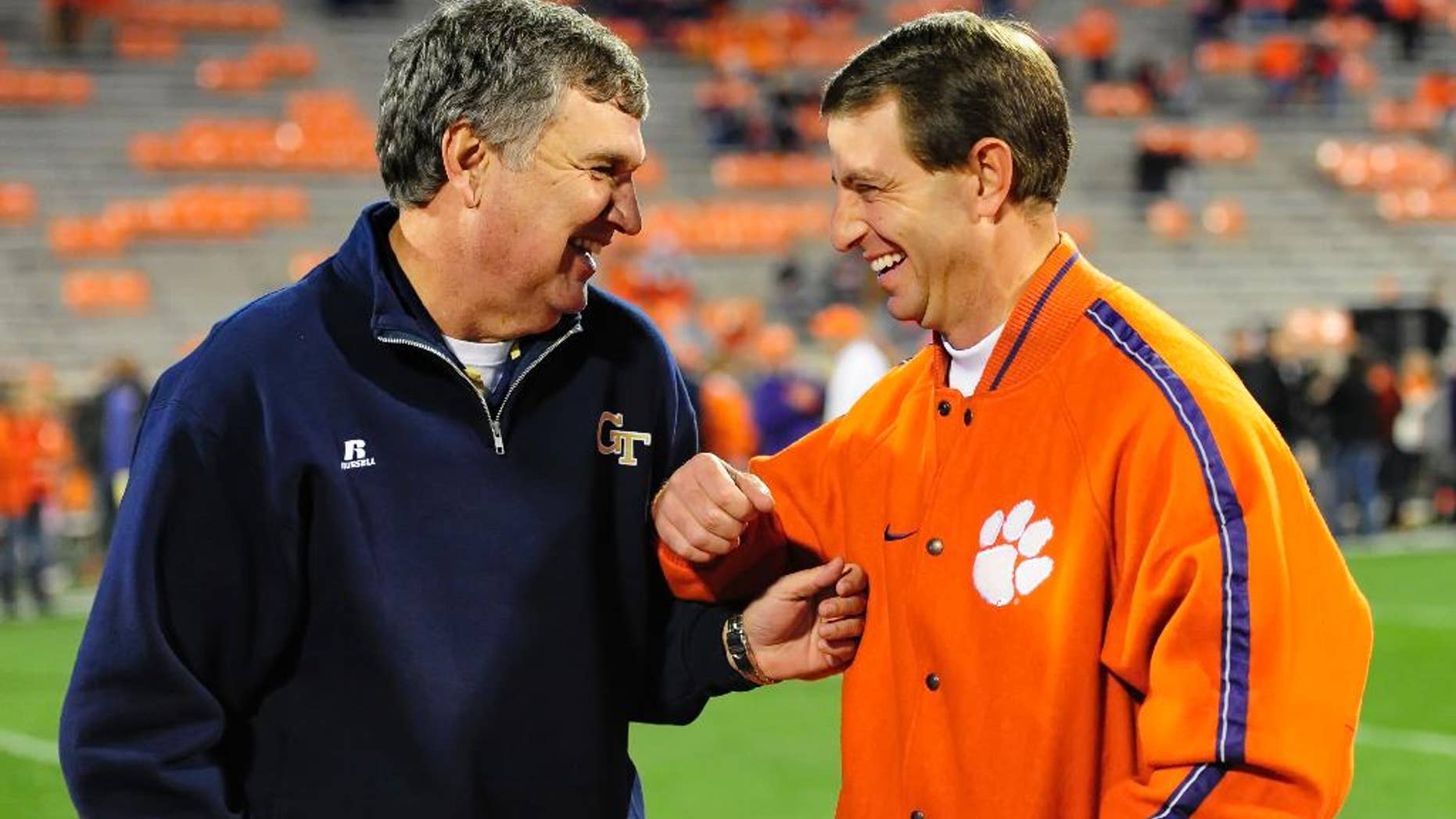 FILE - In this Nov. 14, 2013, file photo, Georgia Tech head coach Paul Johnson, left, laughs with Clemson coach Dabo Swinney before an NCAA college football game in Clemson, S.C. No. 24 Georgia Tech's running attack, which ranks second in the nation, will be tested by No. 18 Clemson's defense, which ranks second overall and No. 4 against the run, on Saturday, Nov. 15, 2014, in Atlanta. (AP Photo/ Richard Shiro, File)
