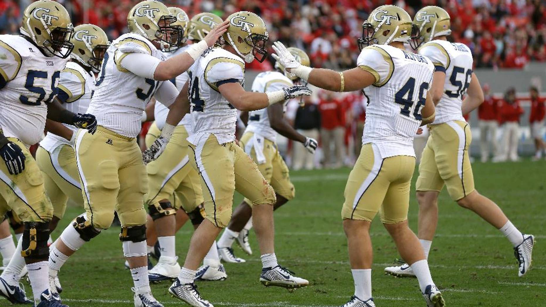 Georgia Tech's Matt Connors, center, is congratulated by teammates following Connors' touchdown against North Carolina State during the second half of an NCAA college football game in Raleigh, N.C., Saturday, Nov. 8, 2014. Georgia Tech won 56-23. (AP Photo/Gerry Broome)