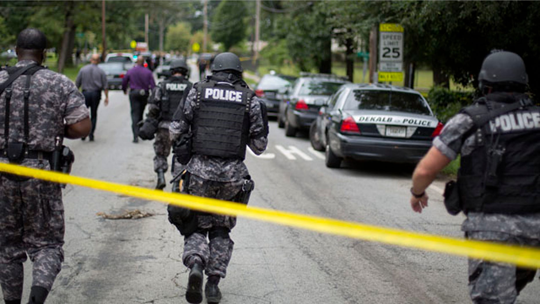 Aug. 20, 2013: Dekalb County Police SWAT officers run toward Ronald E. McNair Discovery Learning Academy after reports of a gunman entered the school.