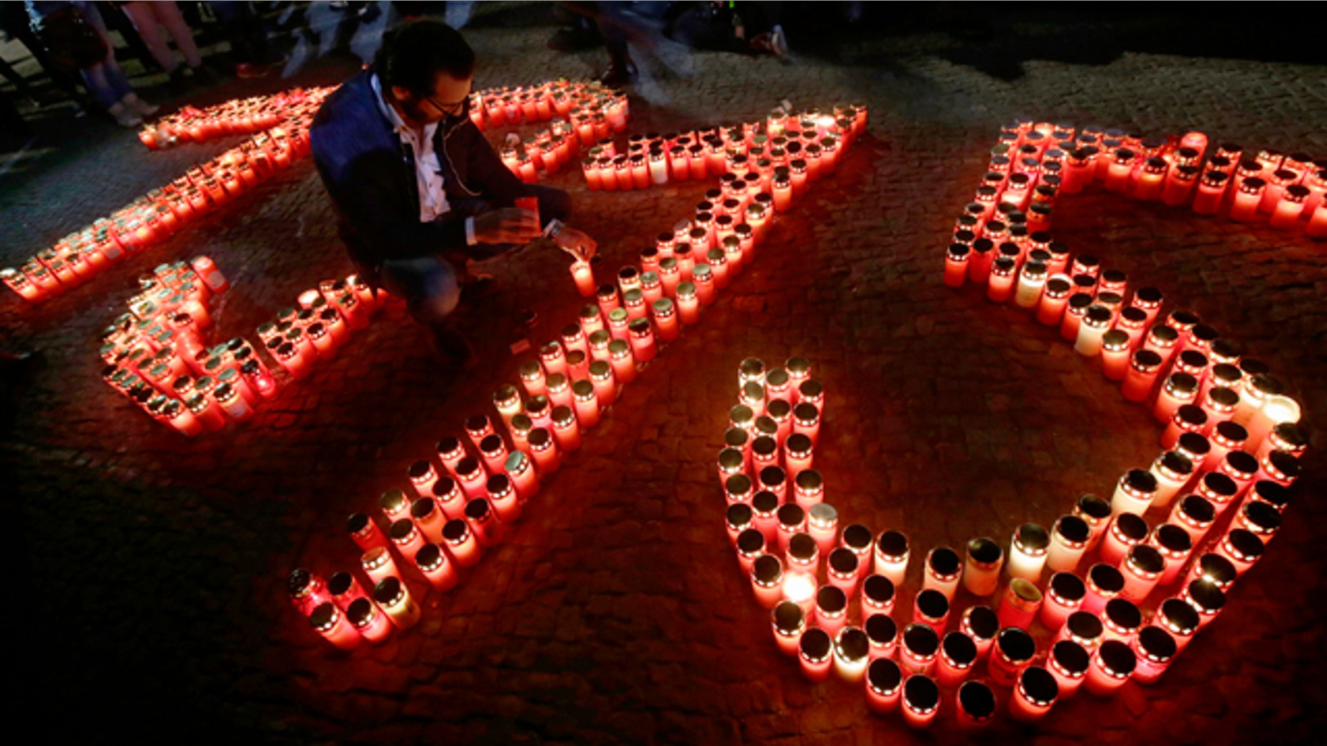 April 23, 2015: A man places a candle in front of the Brandenburg Gate to build the year 1915 during a demonstration after an ecumenical service remembering the Armenian 'slaughter' at the Berlin Cathedral Church in Berlin. (AP Photo/Michael Sohn)