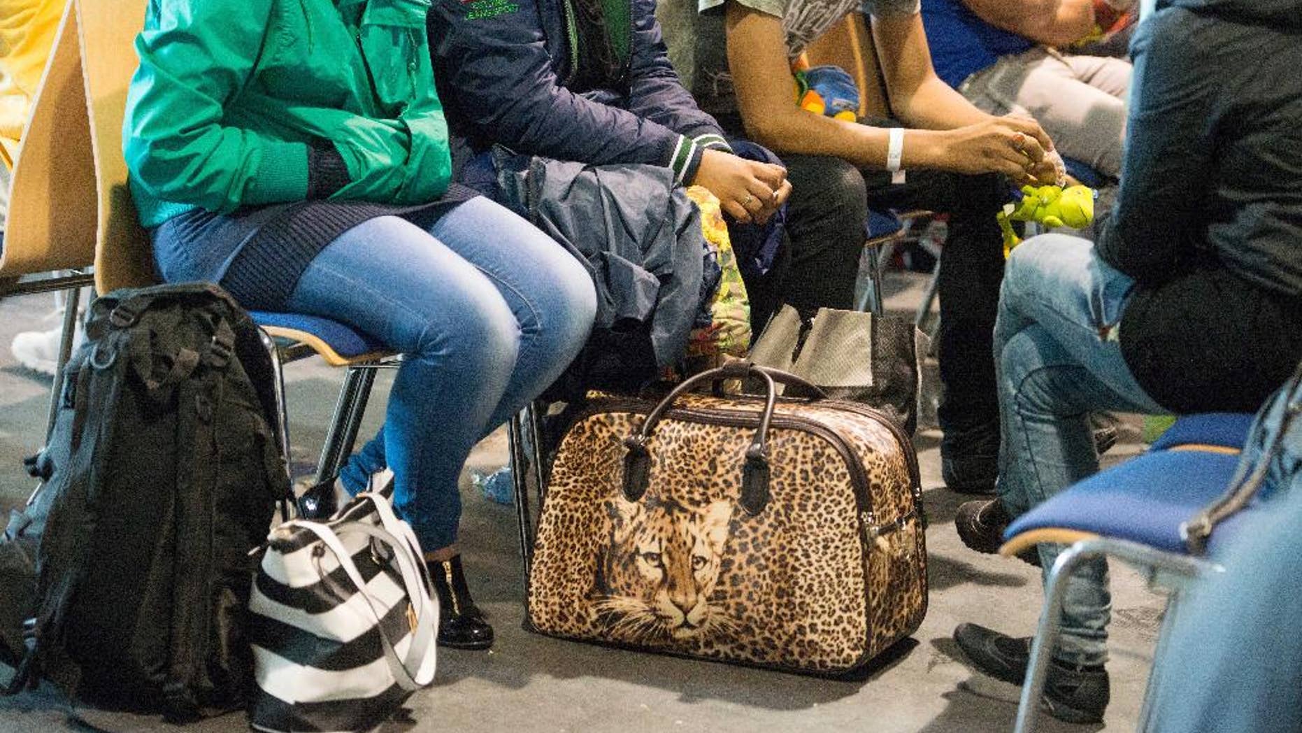 FILE - In this July 14, 2015 file photo migrants wait to be registered at the police station in Passau, southern Germany. Migrants from the Balkans have very little chance of winning asylum in Germany and will be billed for the cost of being deported, according to a video released Friday, Aug. 7, 2015 by German authorities hoping to stop a stream of applicants from southeastern Europe. (Armin Weigel/dpa via AP, File)