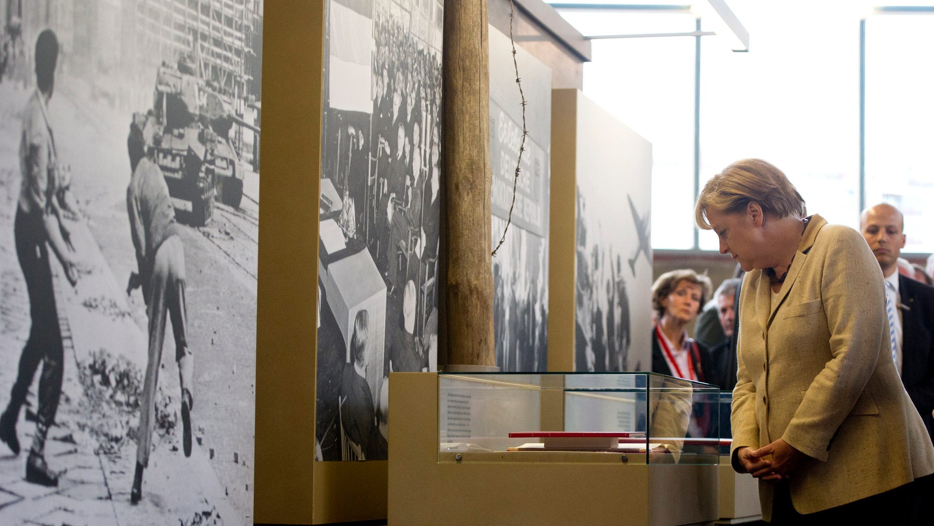 German Chancellor Angela Merkel views exhibits at a permanent exhibition on Germany's Cold War past at what was once one of East Berlin's busiest border crossings, in Berlin, Germany, Wednesday, Sept. 14, 2011. The exhibition is housed in the restored 1960's building where passport and customs checks were carried out at Berlin's Friedrichstrasse station. It was popularly known as the "Traenenpalast," or "Palace of Tears."