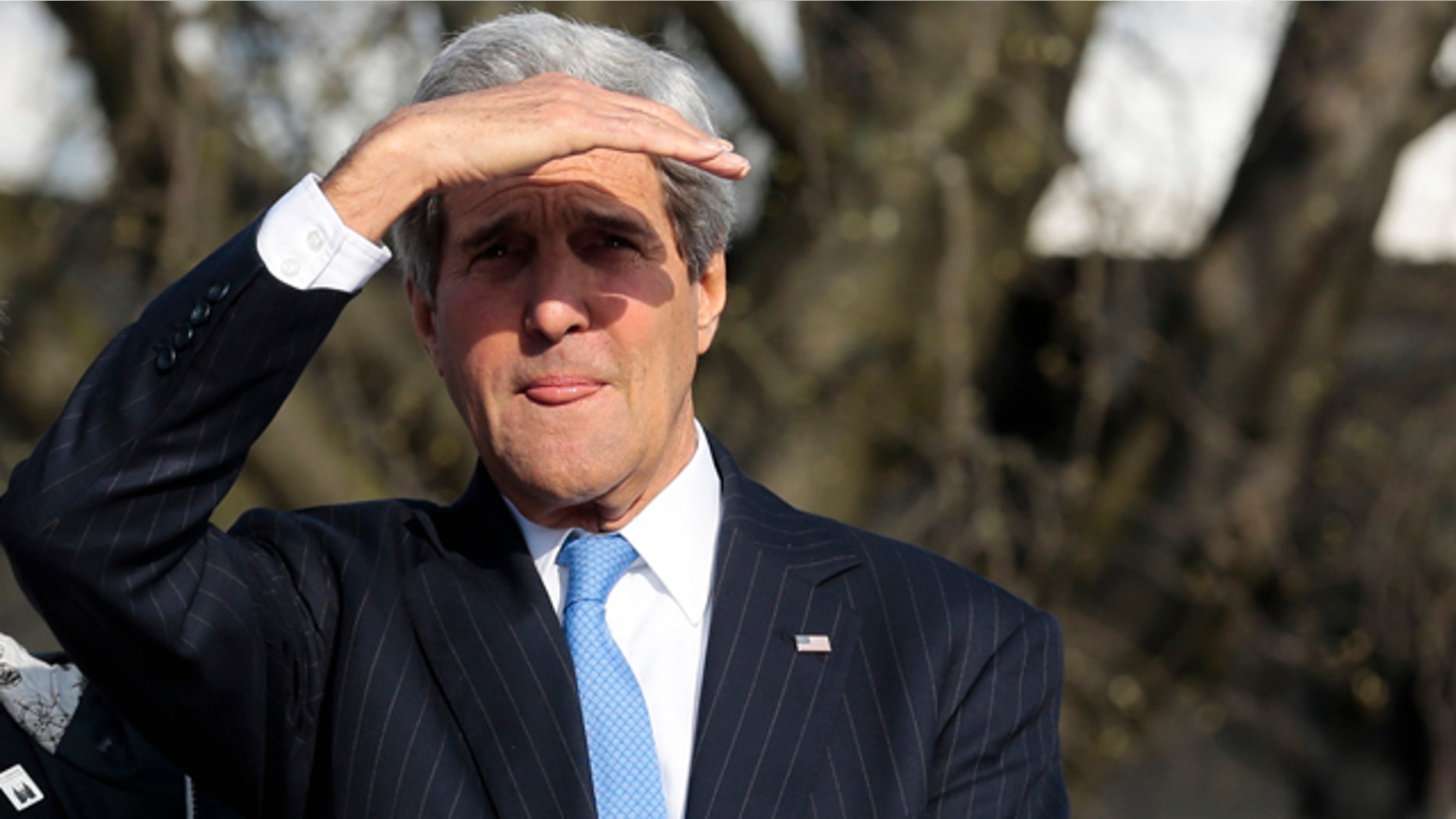 April 15, 2015: United States Secretary of State John Kerry shields his eyes against the sun as he uses a boat on his way to a working session during a meeting of the G7 Foreign Ministers in Luebeck, Germany. The meeting is being held ahead of the G7 leaders summit in Germany from June 7 to 8, 2015. (AP Photo/Markus Schreiber)