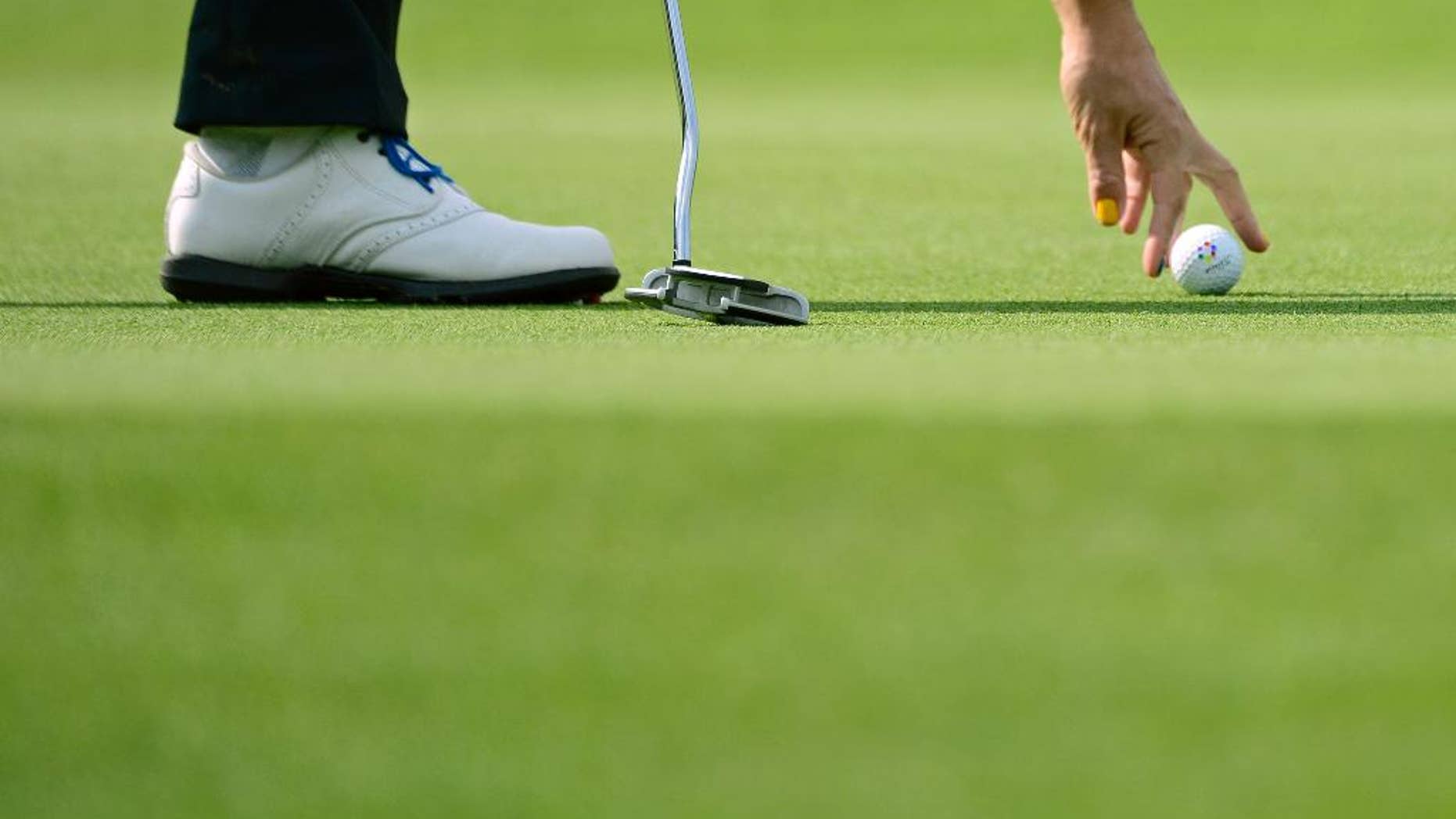 A European player places a ball in the foursomes on Day1 at the Solheim Cup golf tournament in St. Leon-Rot, southern Germany, Friday, Sept. 18, 2015. (AP Photo/Jens Meyer)