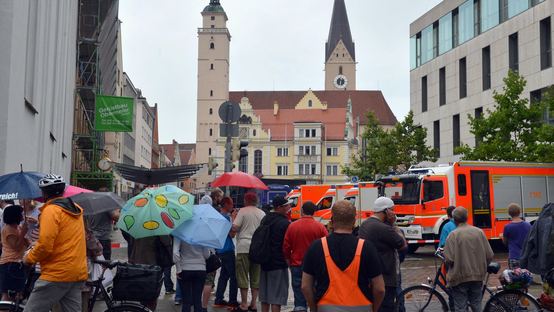 Aug. 19, 2013 - Onlookers stand in front of city hall in Ingolstadt, Germany, after a man took several hostages. Police spokesman Guenther Beck said it wasn't clear what weapons the man might have or what he wants.