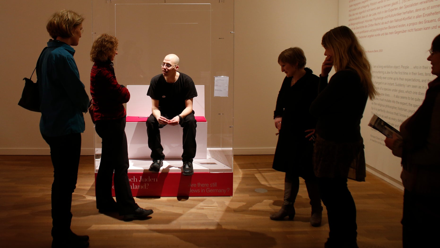 March 22, 2013 FILE photo: Visitors surround Ido Porat, the 1st person acting as the "Jew in a glass box," at the exhibition "The Whole Truth- everything you always wanted to know about Jews" at the Jewish Museum in Berlin.