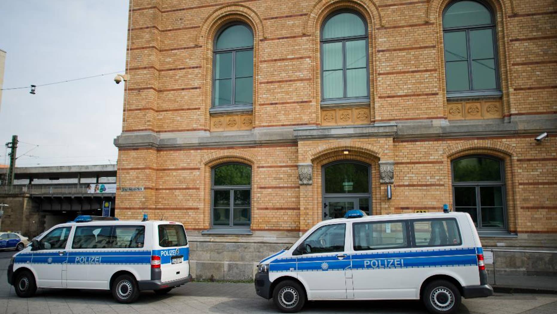 Police cars park in front of the police station at the railway station in Hannover, Germany, Monday, May 18, 2015. Hannover prosecutors said a 39-year-old police officer is being investigated on allegations he abused two immigrants while they were in custody and boasted about it over social media. (Julian Stratenschultedpa via AP)