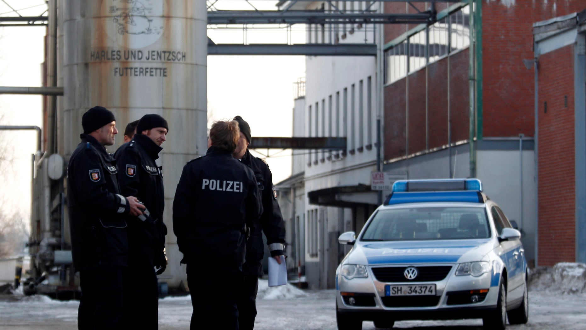 Jan. 5, 2011: In this picture, police stand in front of an animal feed products company in Uetersen, northern Germany that was searched and temporarily closed by authorities. German authorities have stopped more than 4,700 farms from selling their meat and eggs as a precautionary measure against a growing scandal over animal feed contaminated with cancer-causing chemicals that is also affecting exports. Authorities believe some 150,000 tons of feed for poultry and swine containing industrial fat have been fed to livestock across Germany. The fat contains dioxins and should not have been in the food.